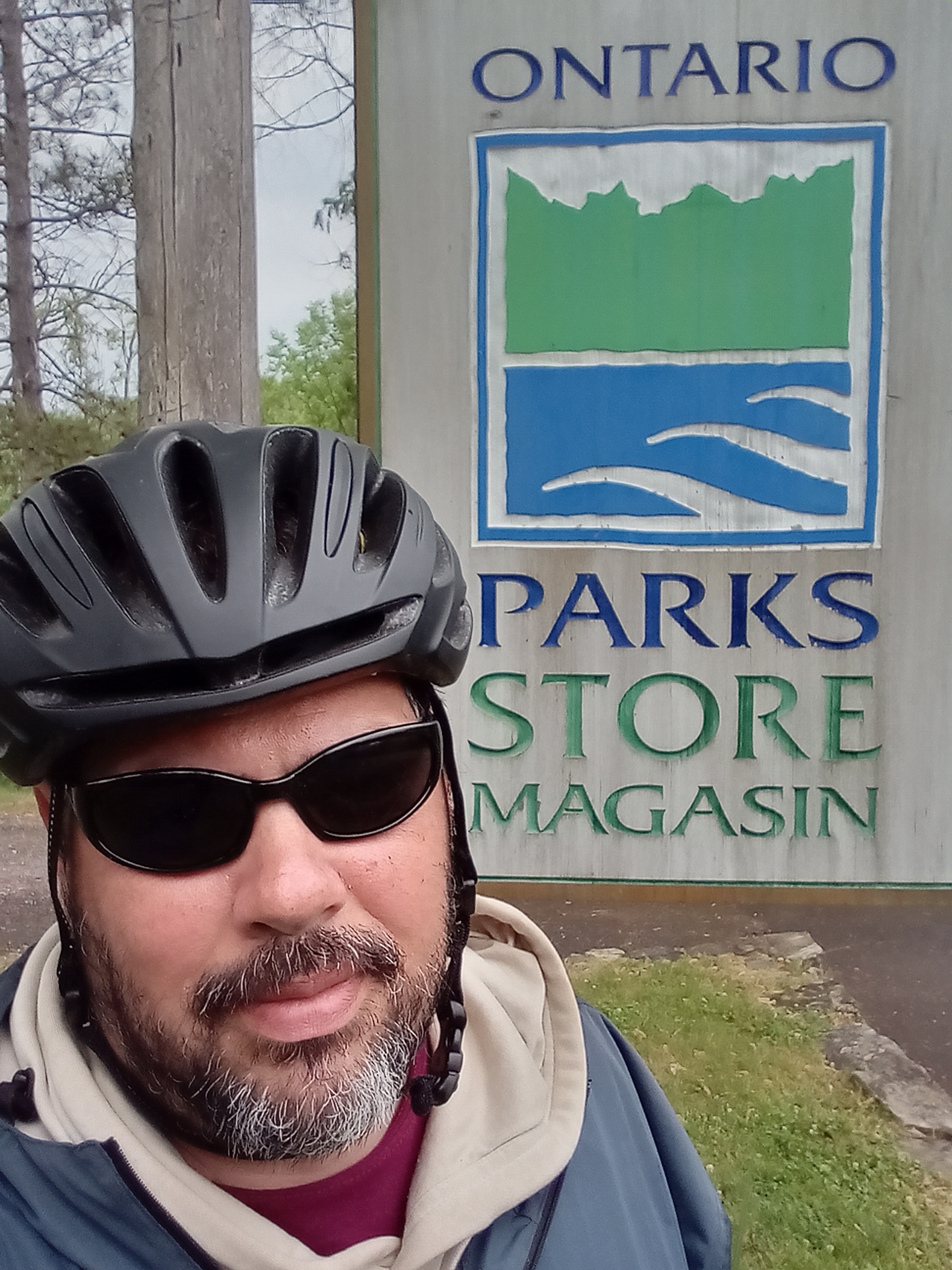 Chris Aubichon in front of an Ontario Parks sign
