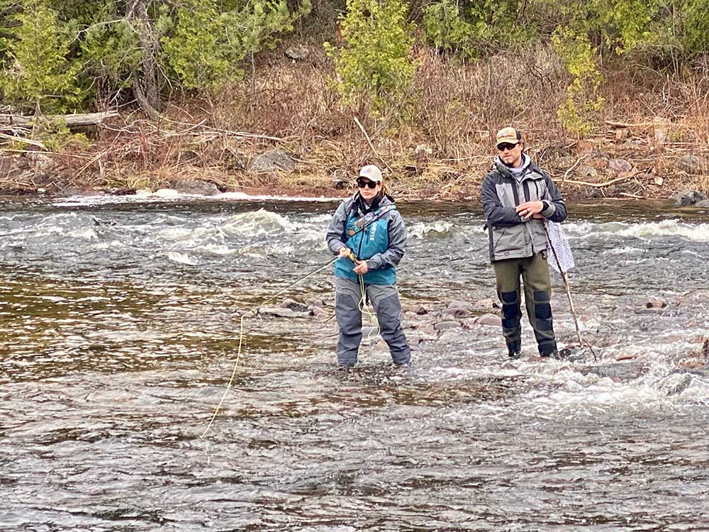 anglers fly fishing in stream
