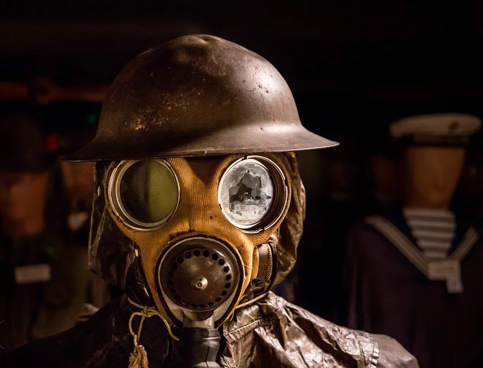 a gas mask from the second World War displayed on a mannequin at the Bunker Military Museum, in a darkened room