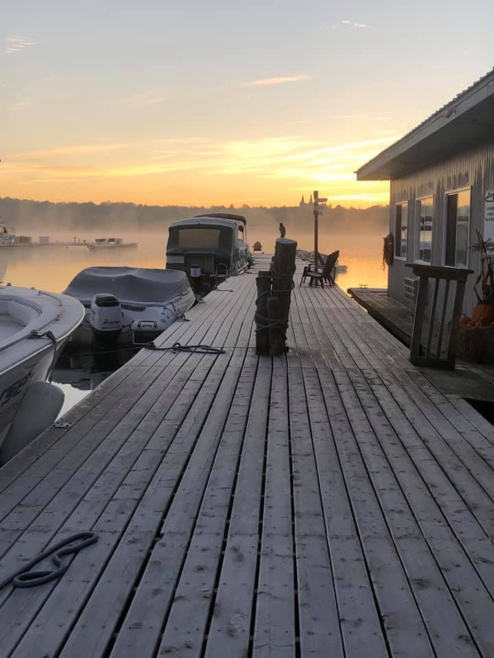 several boats along a misty dock at sunrise