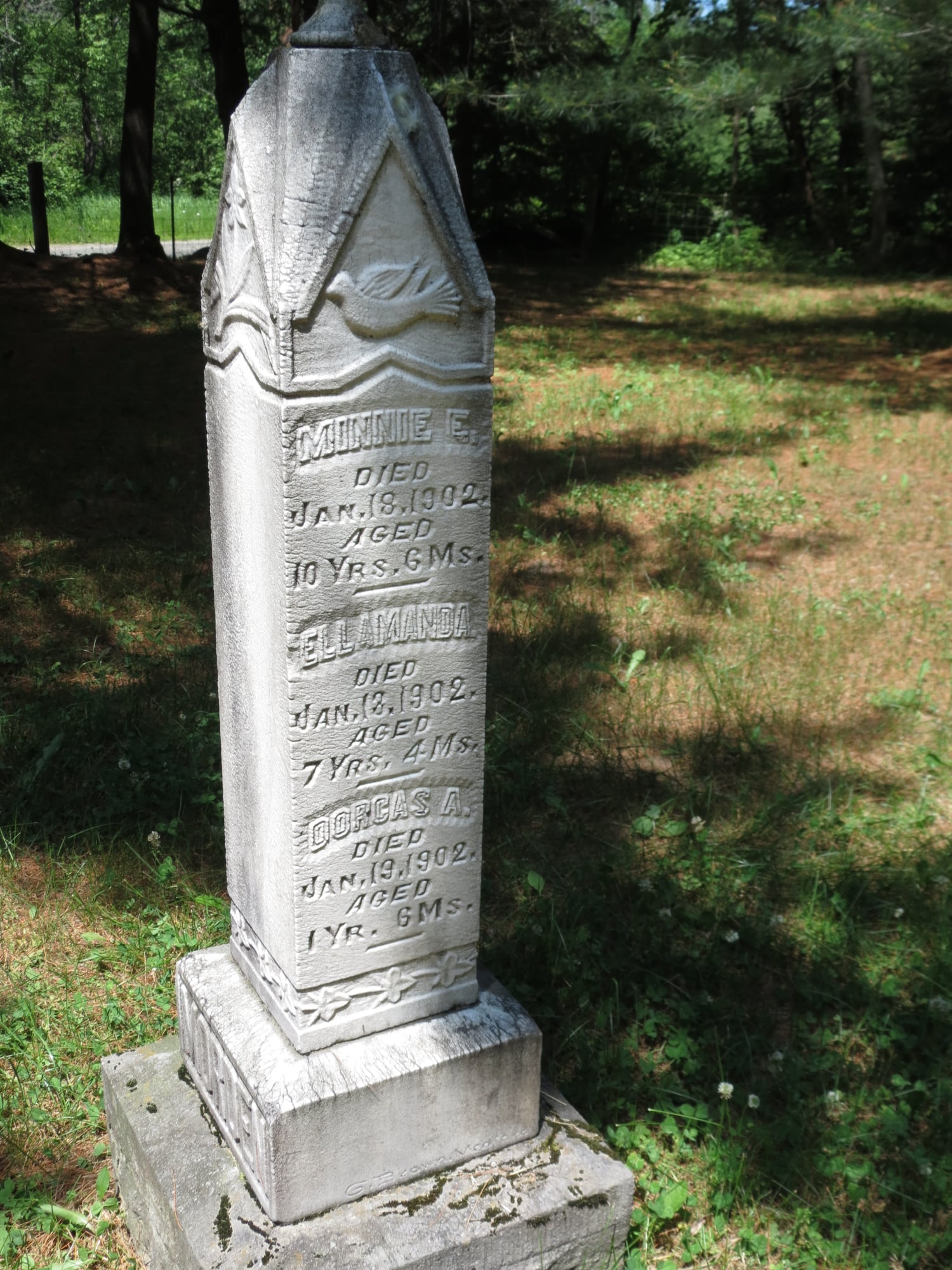 the tall white gravestone marker listing several names from the Morden family, surrounded by green grass and shade trees in the Dufferin Cemetery