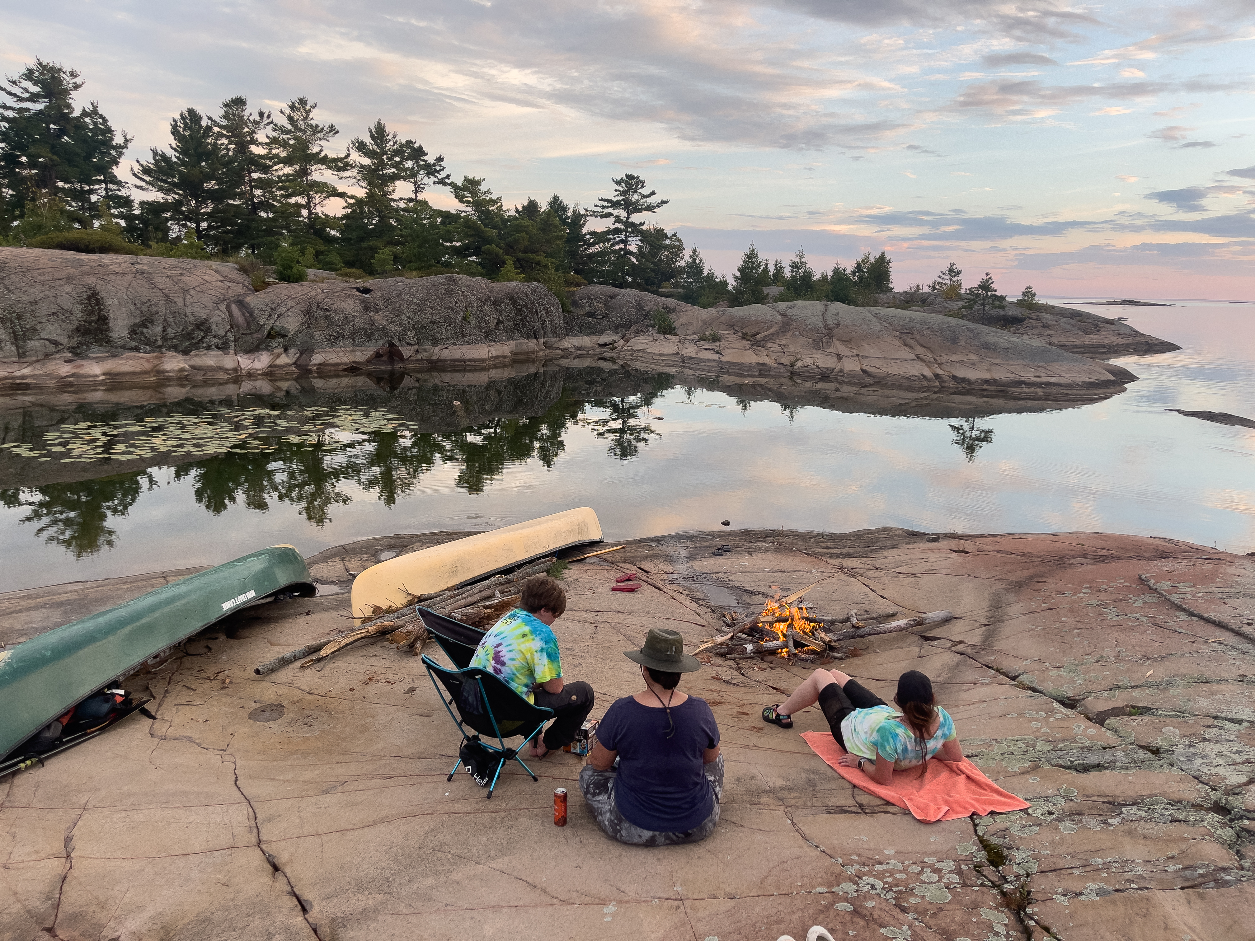 canoeists relax on a rock cap on Philip Edward Island