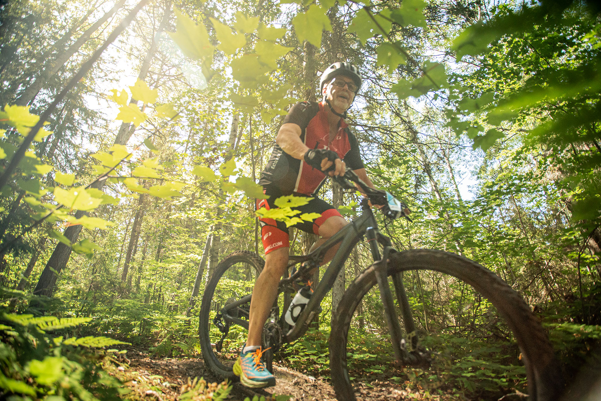 older man cycling along trails in Sudbury's Kivi Park
