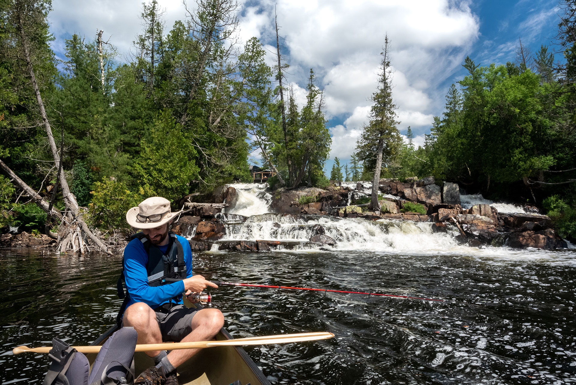 man fishes from a canoe on the Evelyn River in Ontario