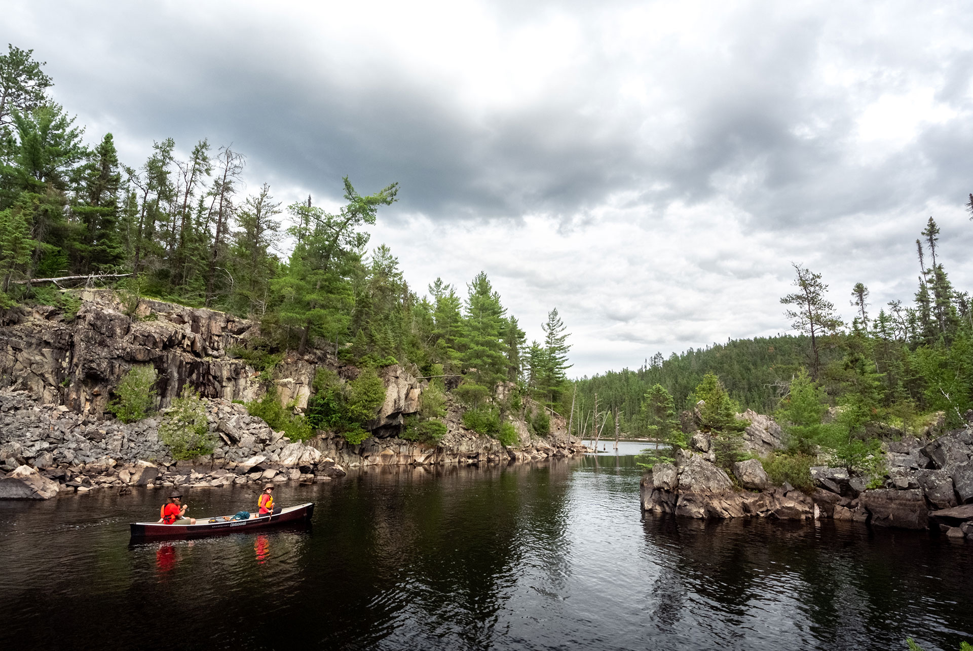 two people paddle a canoe on northeastern Ontario's Evelyn River