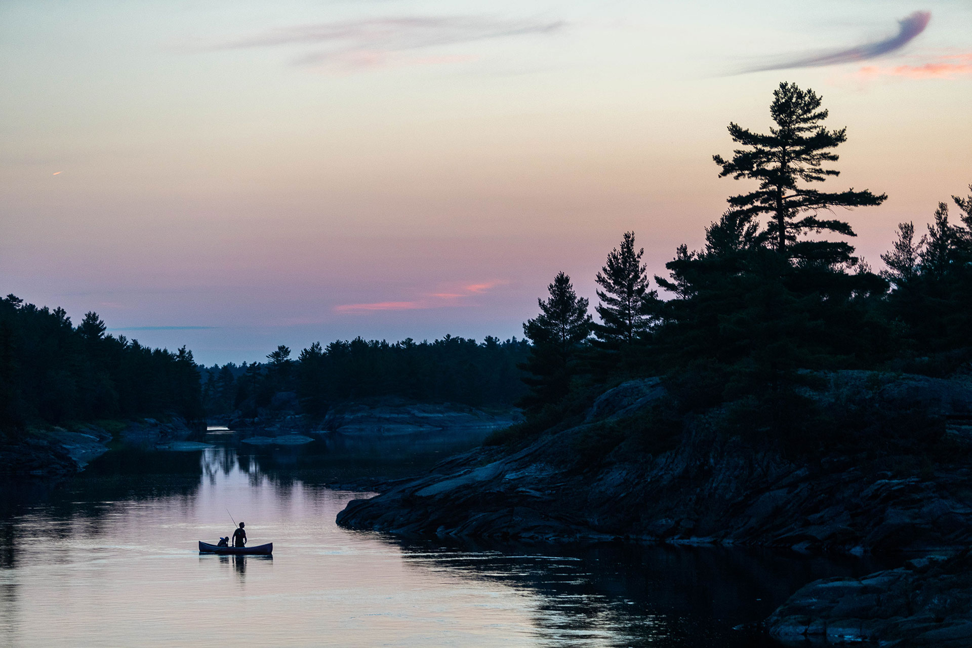 a canoe silhouettted on the French River at dusk
