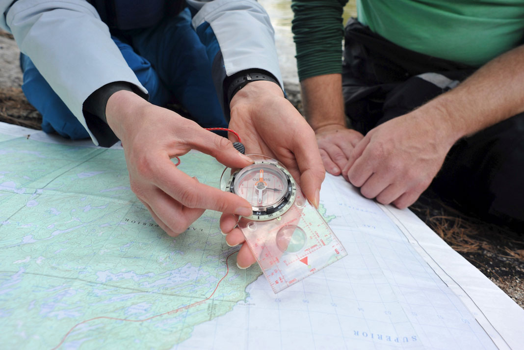 a person demonstrates how to navigate using compass and map