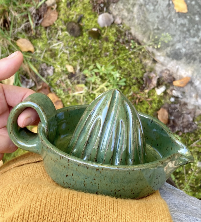 A green ceramic citrus juicer
