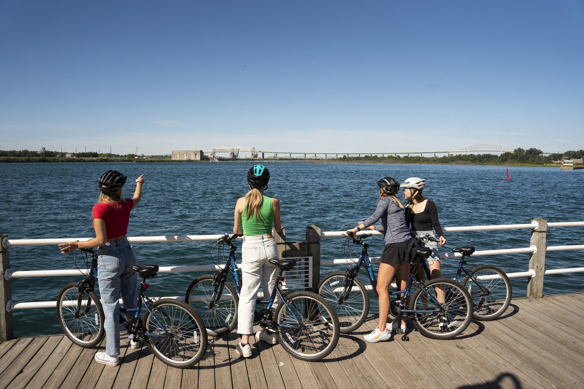 a group of cyclists stop to take photos along the Sault Ste. Marie waterfront