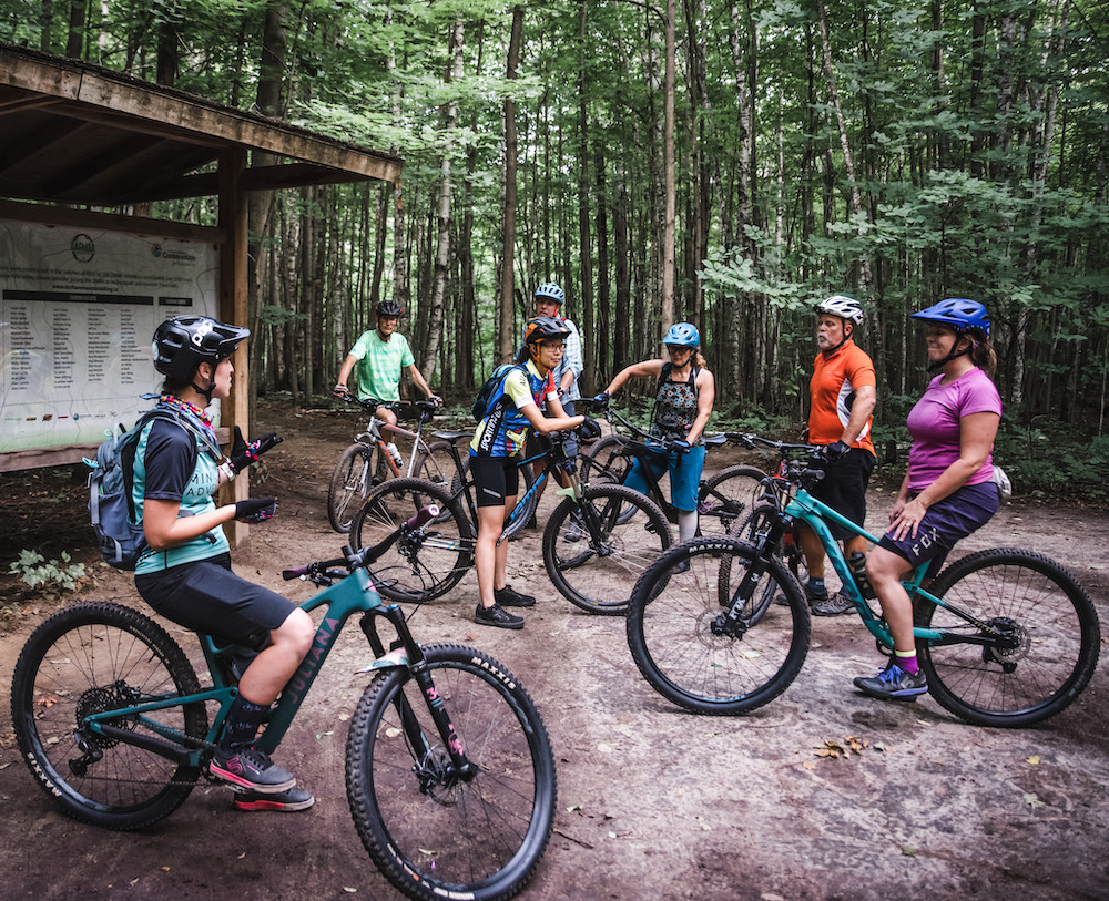 Group of mountain bikers at a trailhead.