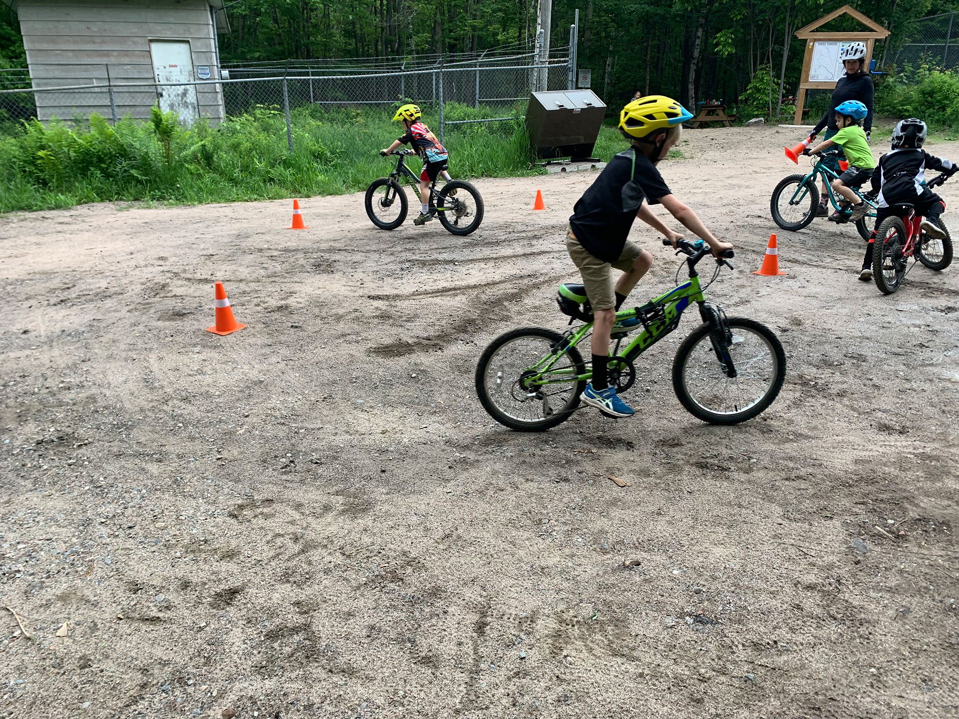 kids ride their bicycles through pylons as part of a cycling class