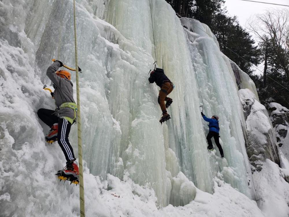 Three people ice climbing 