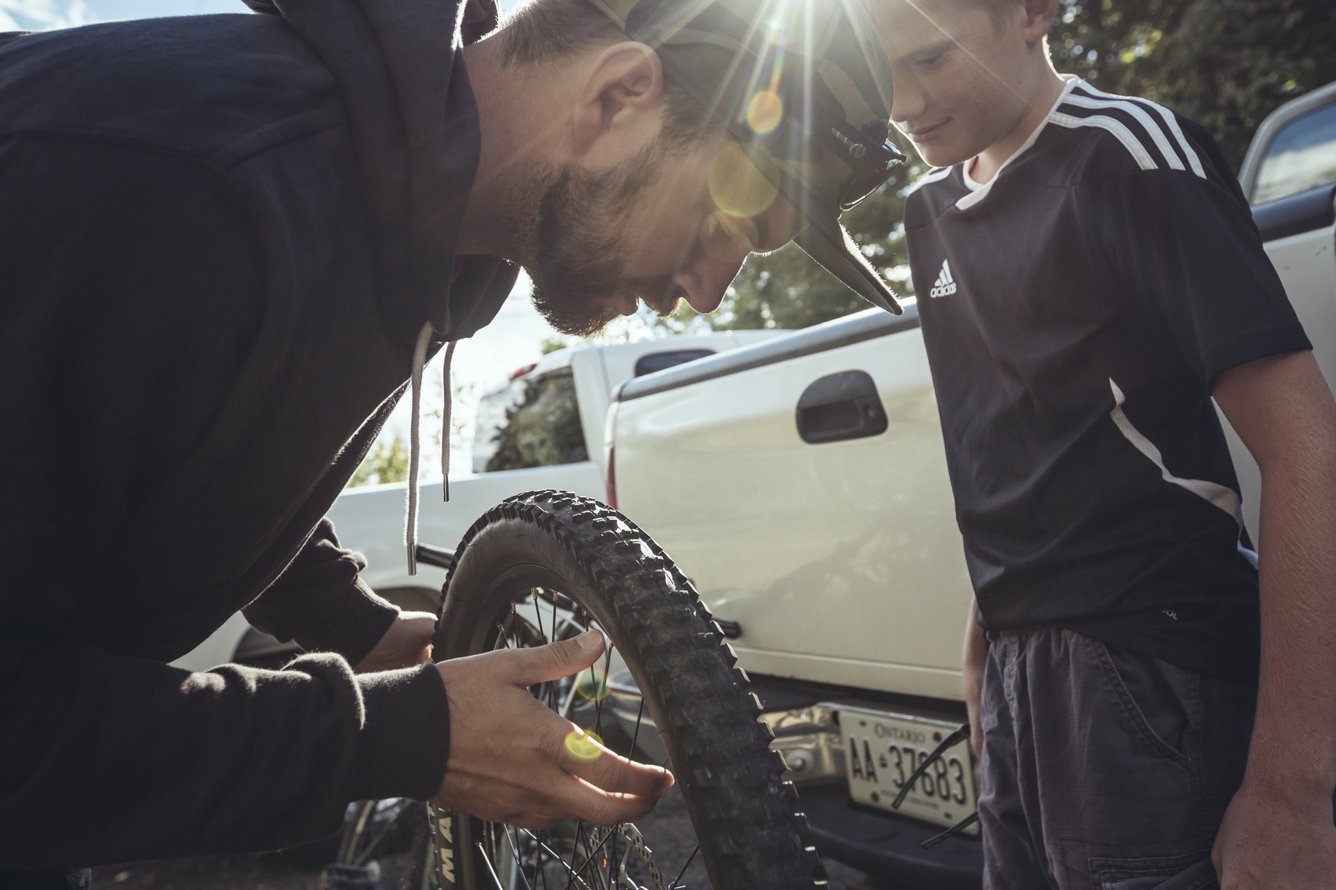 closeup of father and son inspecting bike tire