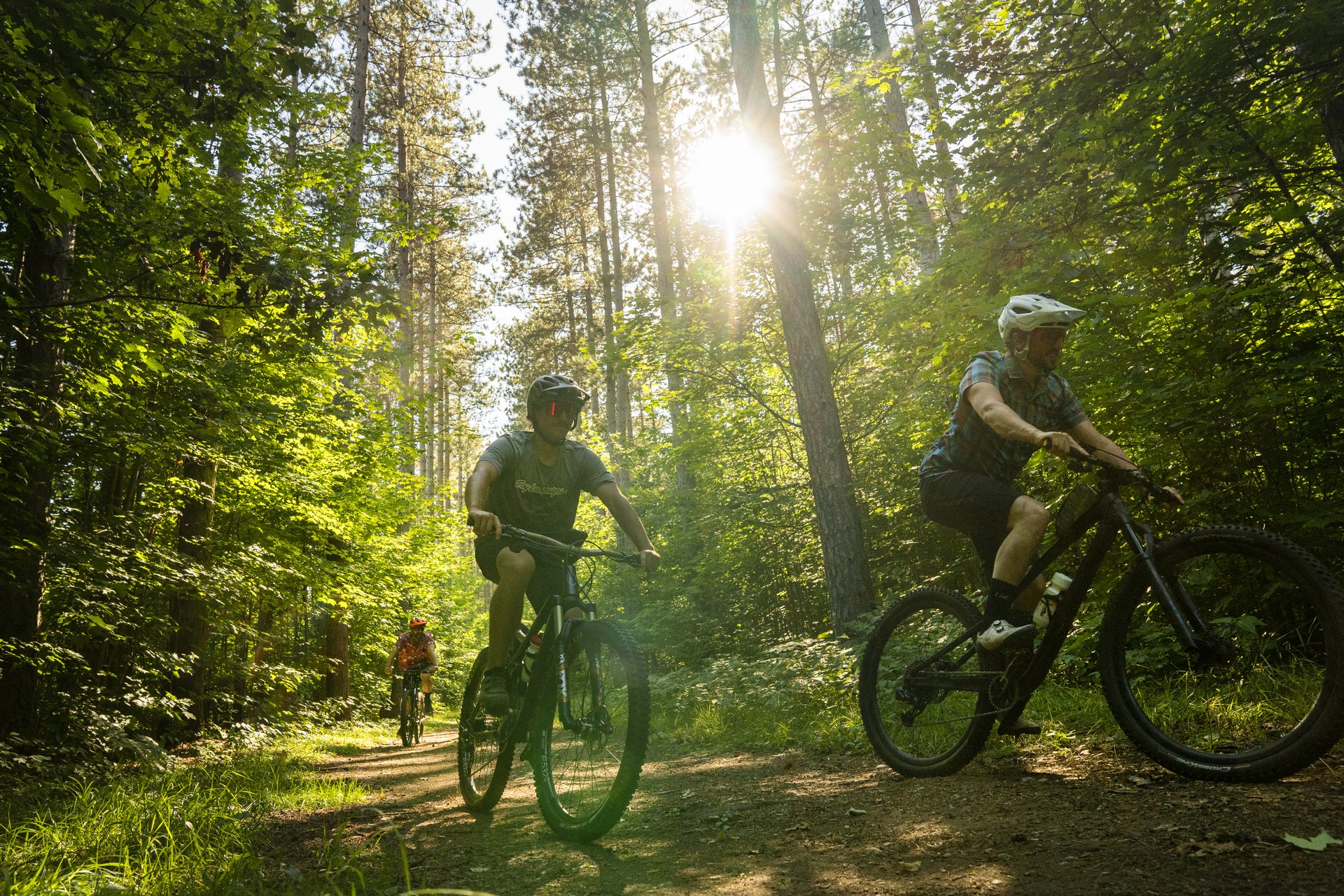 a group of cyclists ride along a forest path at Hiawatha Highlands