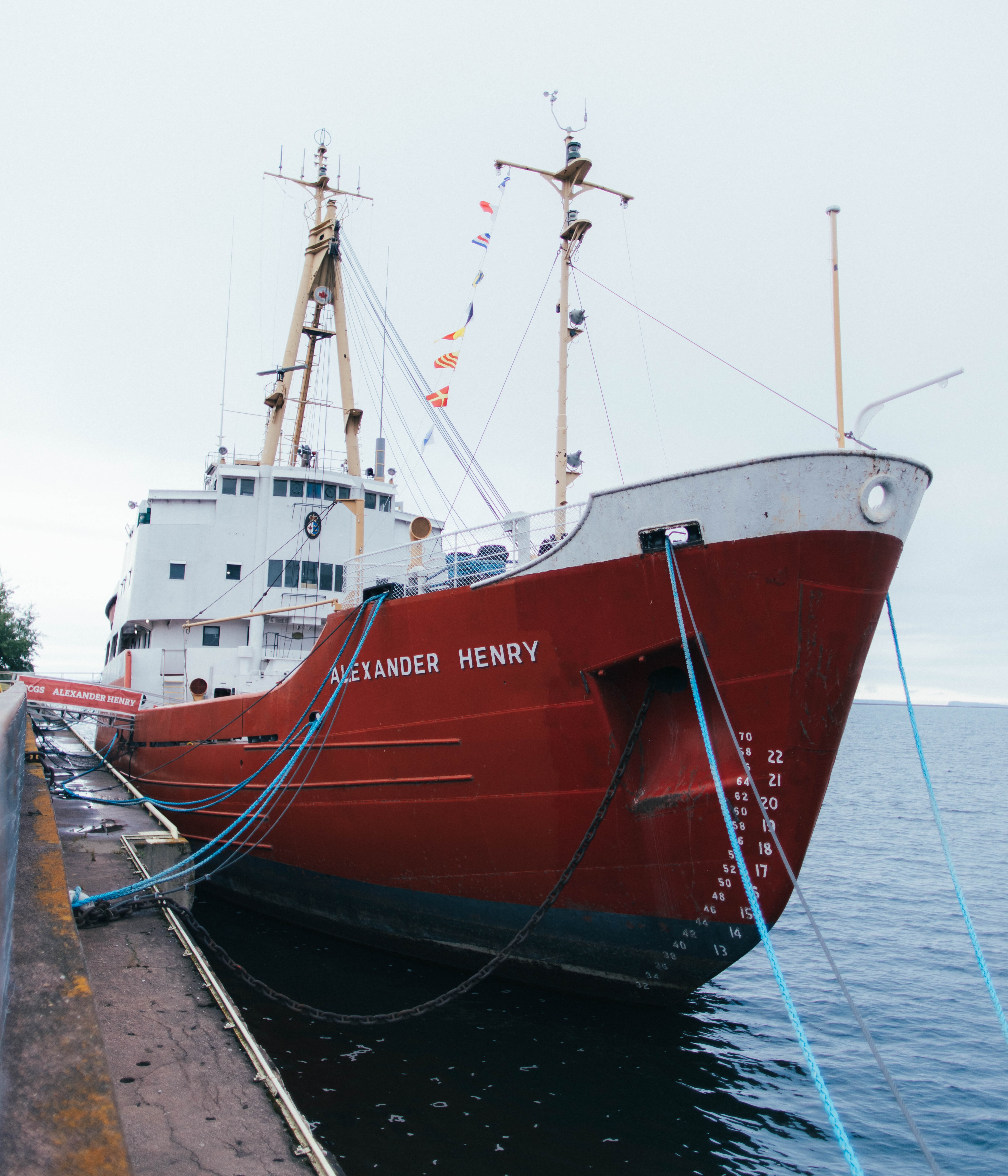 The ship Alexander Henry, a large red and white metal 1950s icebreaker, docked at the Thunder Bay waterfront.