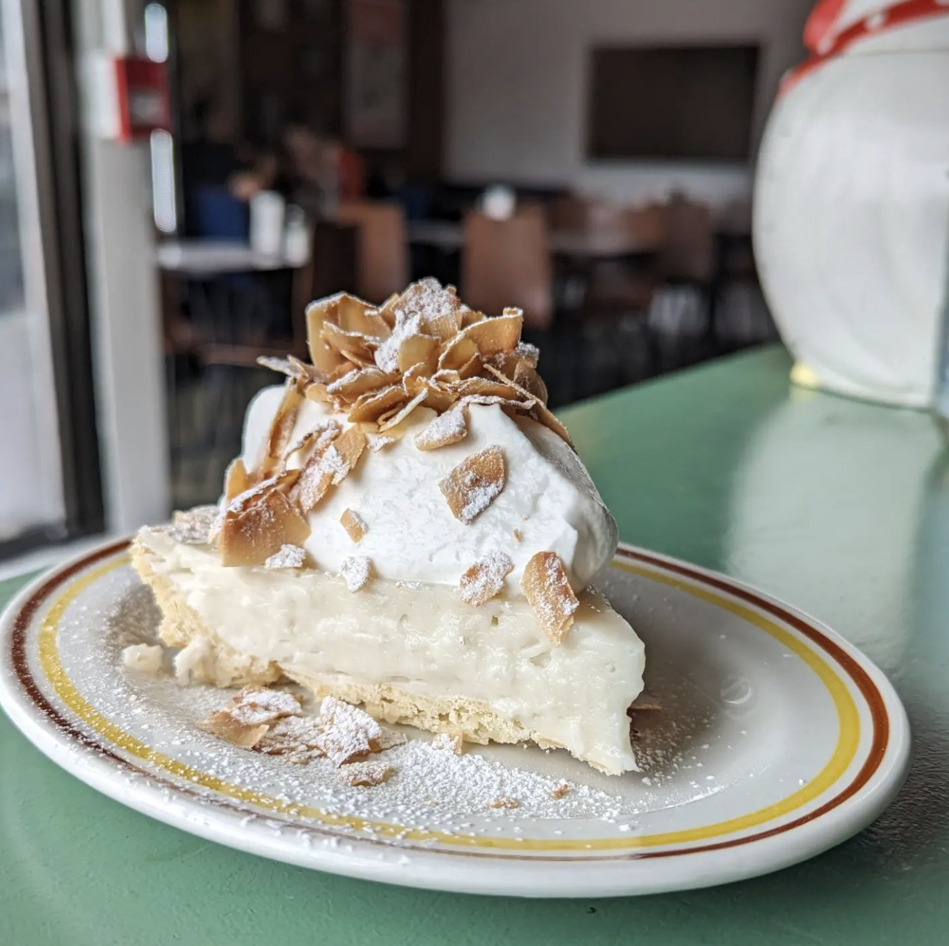 Crossroads vegan-friendly coconut cream pie topped with coconut whip and toasted coconut shavings