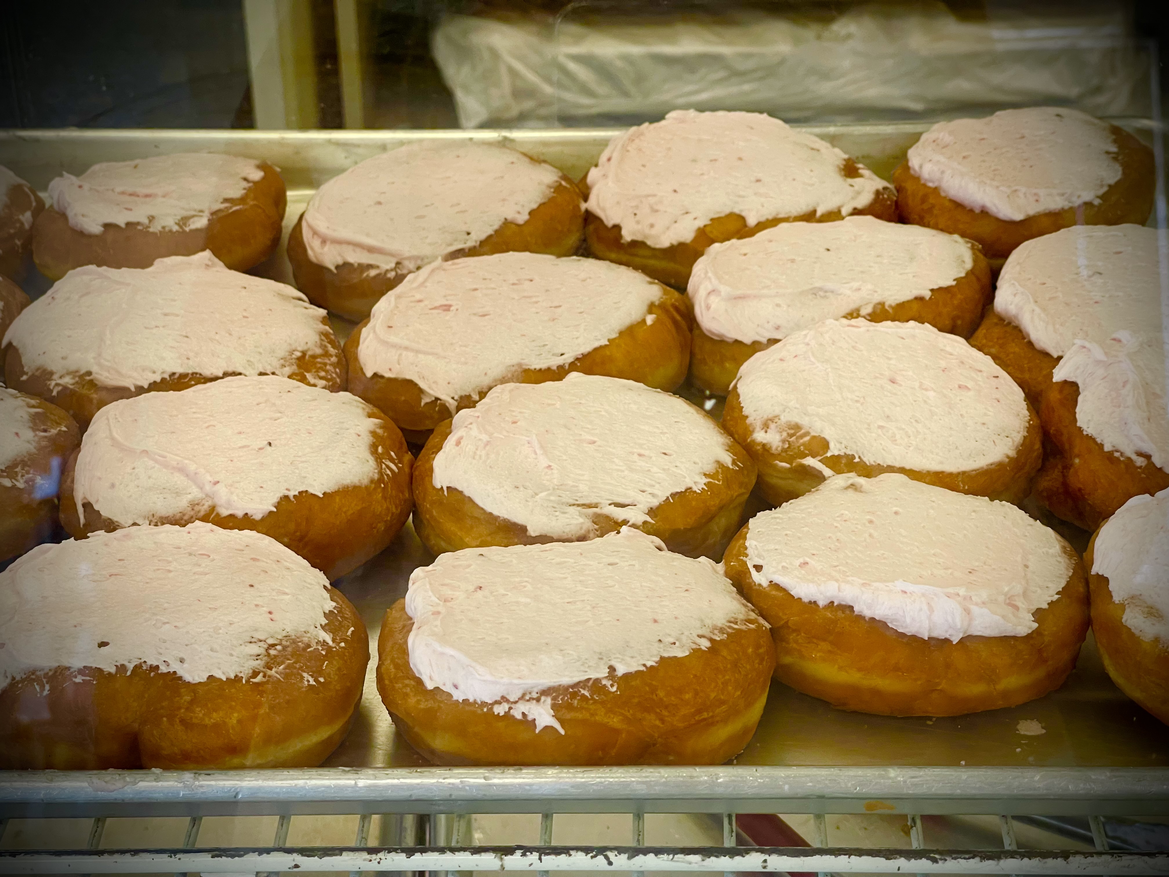 Persians; a tray of golden-brown pastries covered in light pink icing