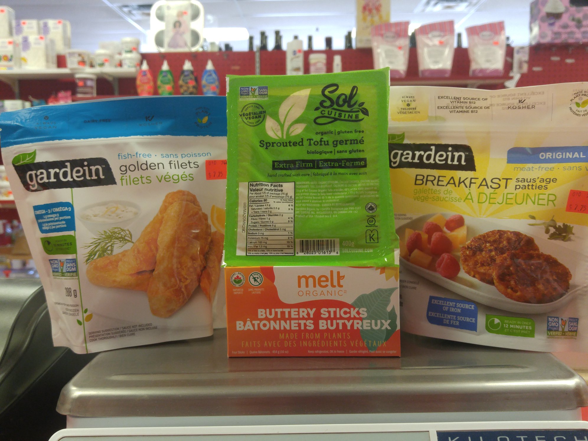 packages of vegan food products at Bins & Bins, with shelves full of groceries in the background.