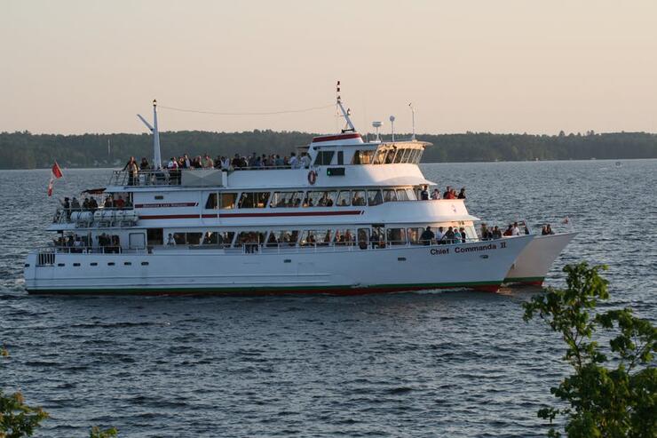 The Commanda 2; a large white cruise ship full of people floating on Lake Nipissing