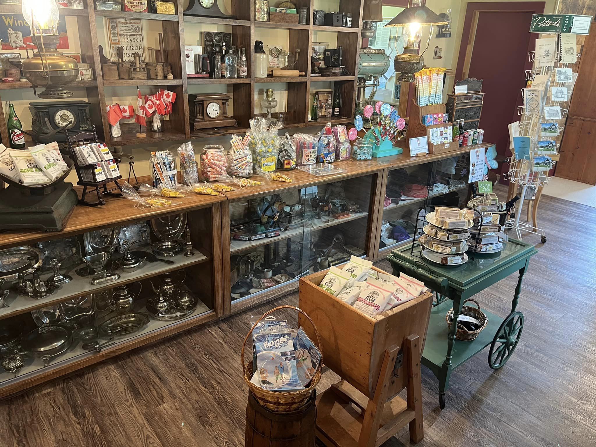 The interior of the Candy Shoppe at the Nipissing Township Museum; a well-stocked candy store decorated with antique jars, shelves and a wooden shop counter.