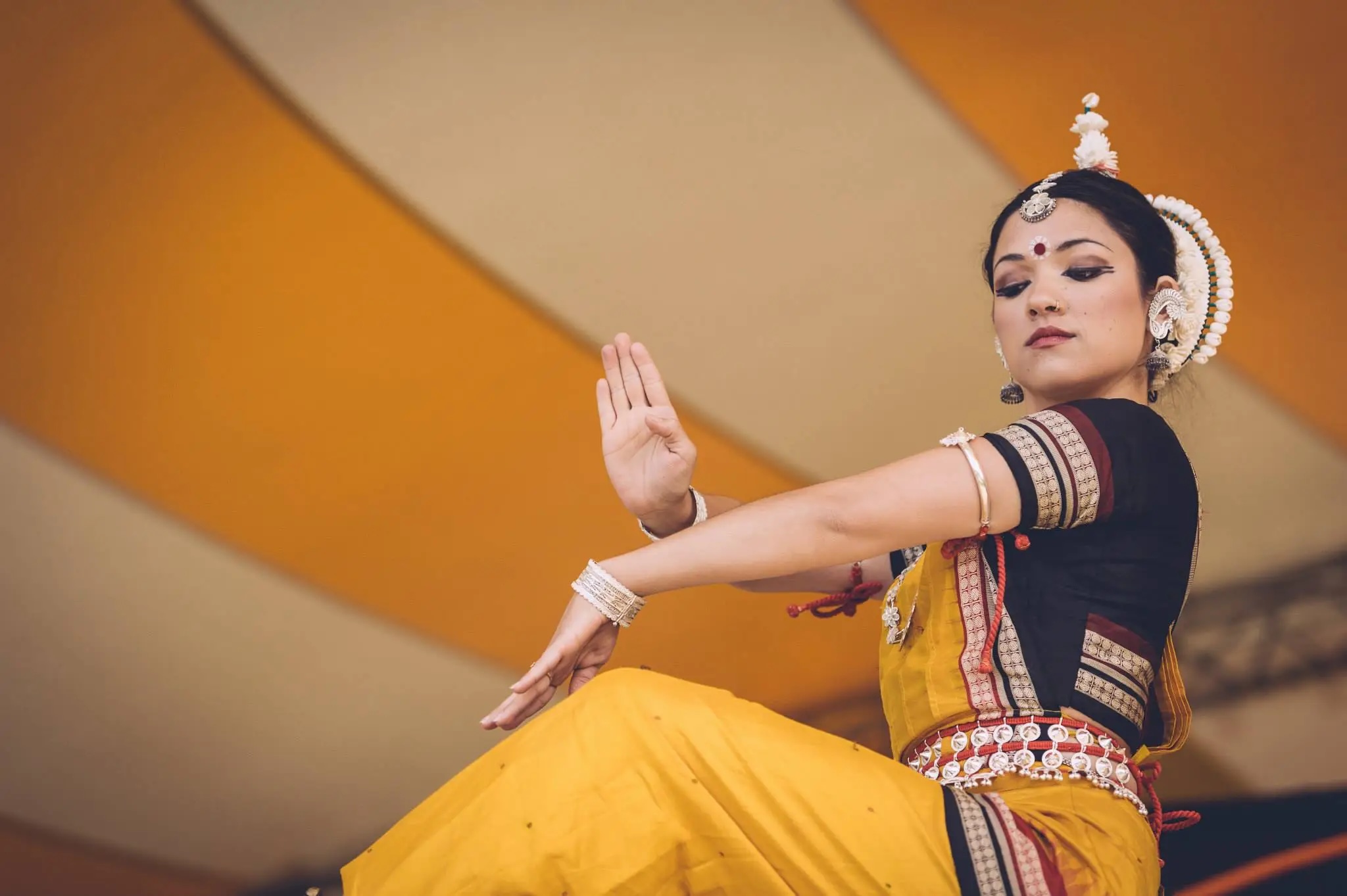 A woman wearing beautiful traditional Indian dress dances onstage at the Festival of India 