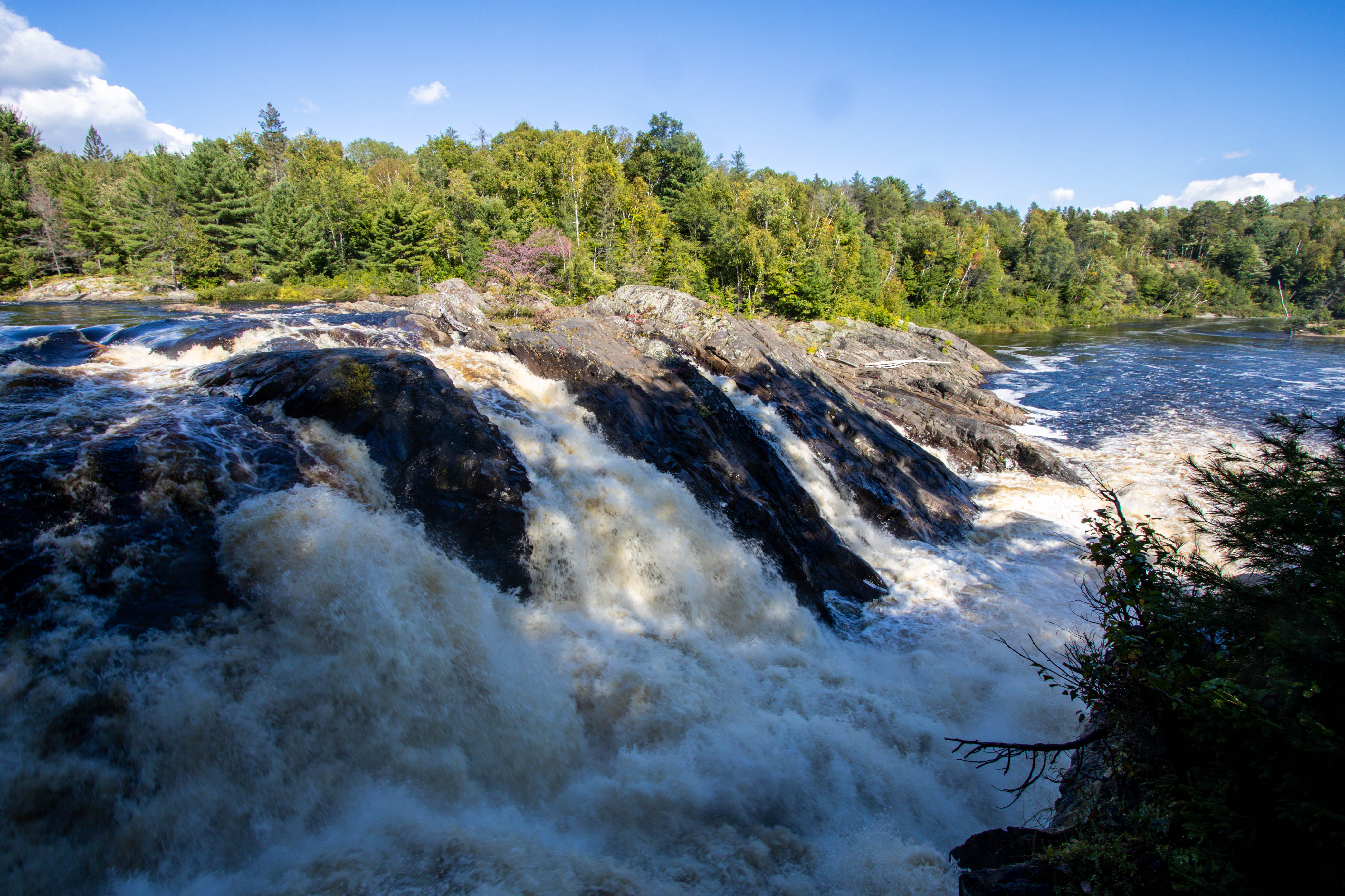 The roaring turbulent waters of Chutes Falls, a long low high-volume waterfall.