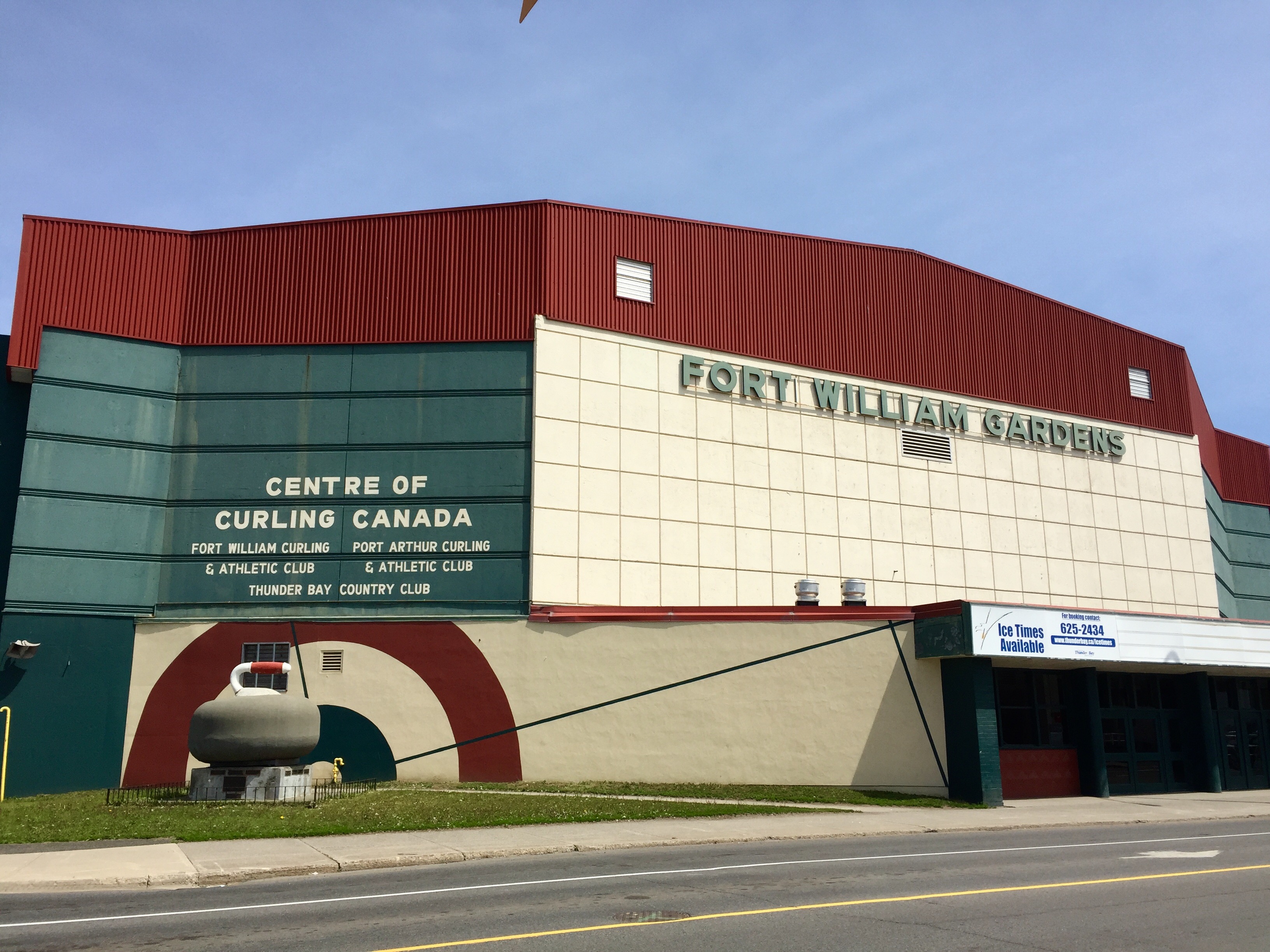 Fort William Gardens; a large, stately red and white arena with a giant curling rock statue outside.