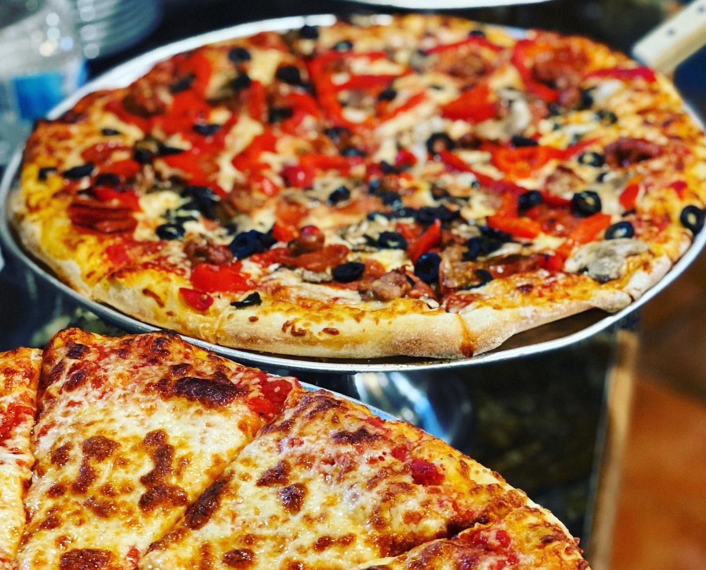 two golden-brown pizzas with colourful vegetable toppings at Fratelli's Kitchen in Sault Ste. Marie