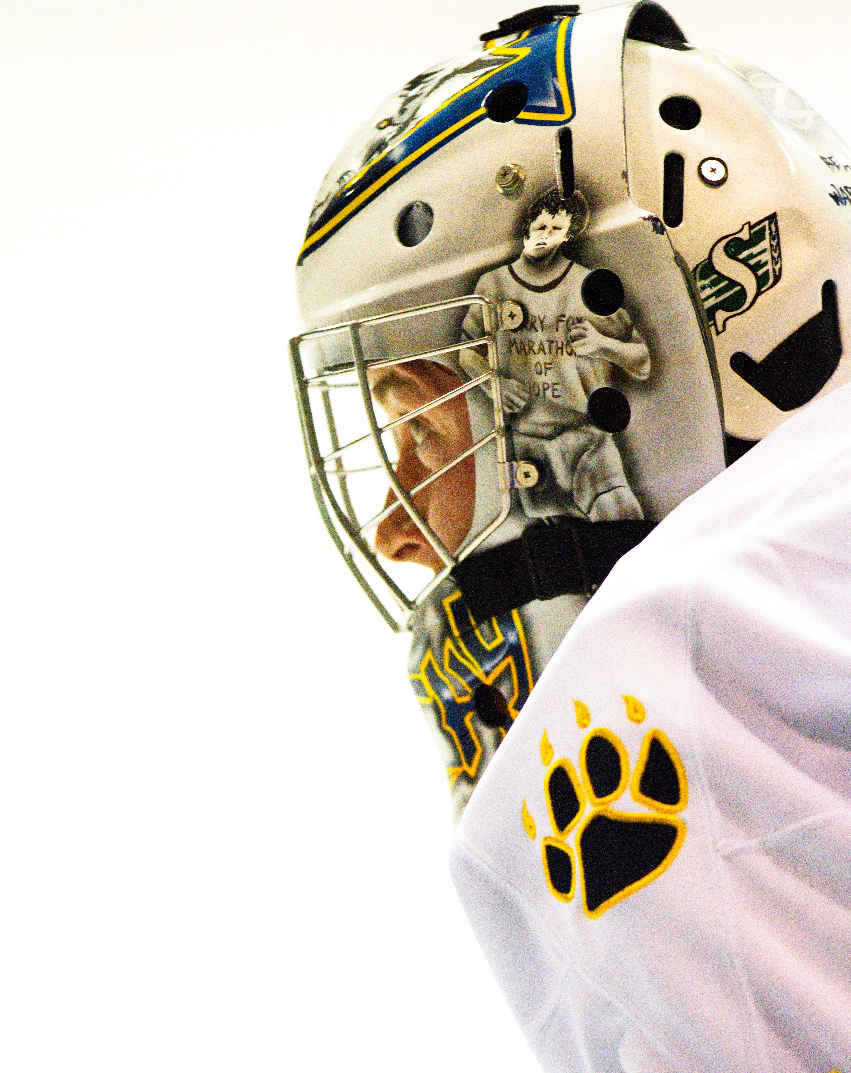 the goalie of the Lakehead Thunderwolves looks down the rink with focus. 