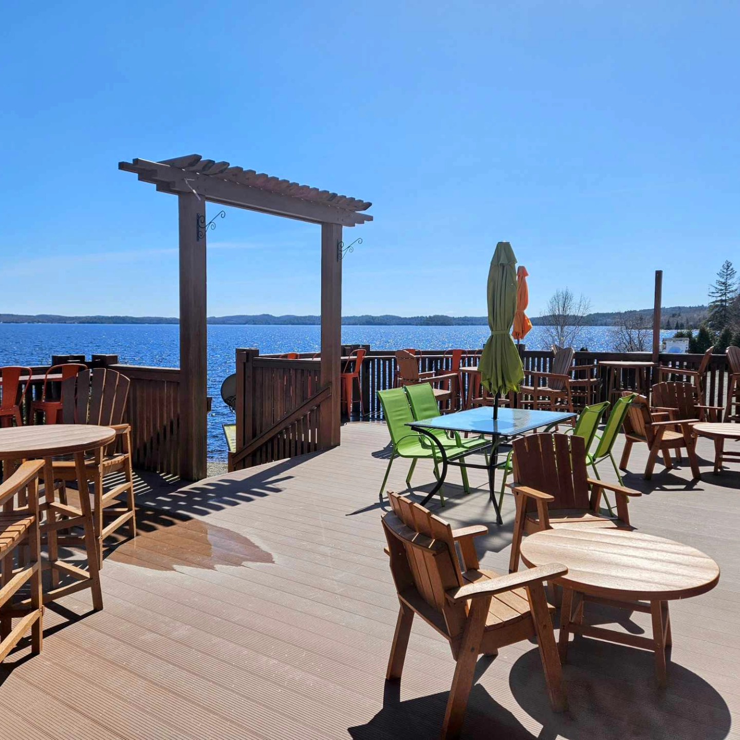 Hiawatha's lakeside patio with a blue sky and patio furniture.
