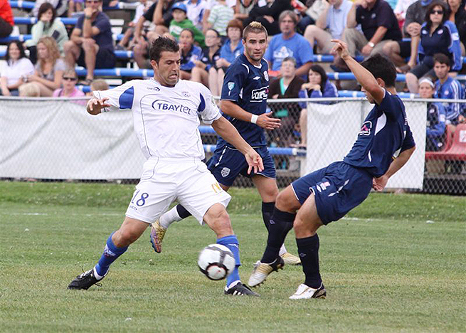 A Thunder Bay Chill player lunging to get the ball around his opponent as they rush to stop him.