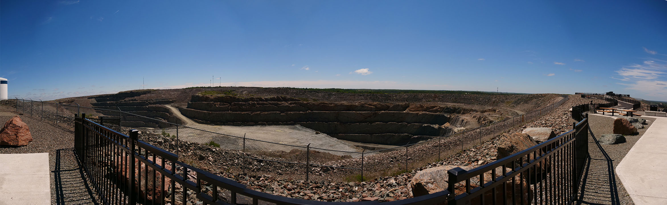 a broad view of the gravelly Hollinger Mine pit under a clear blue sky.