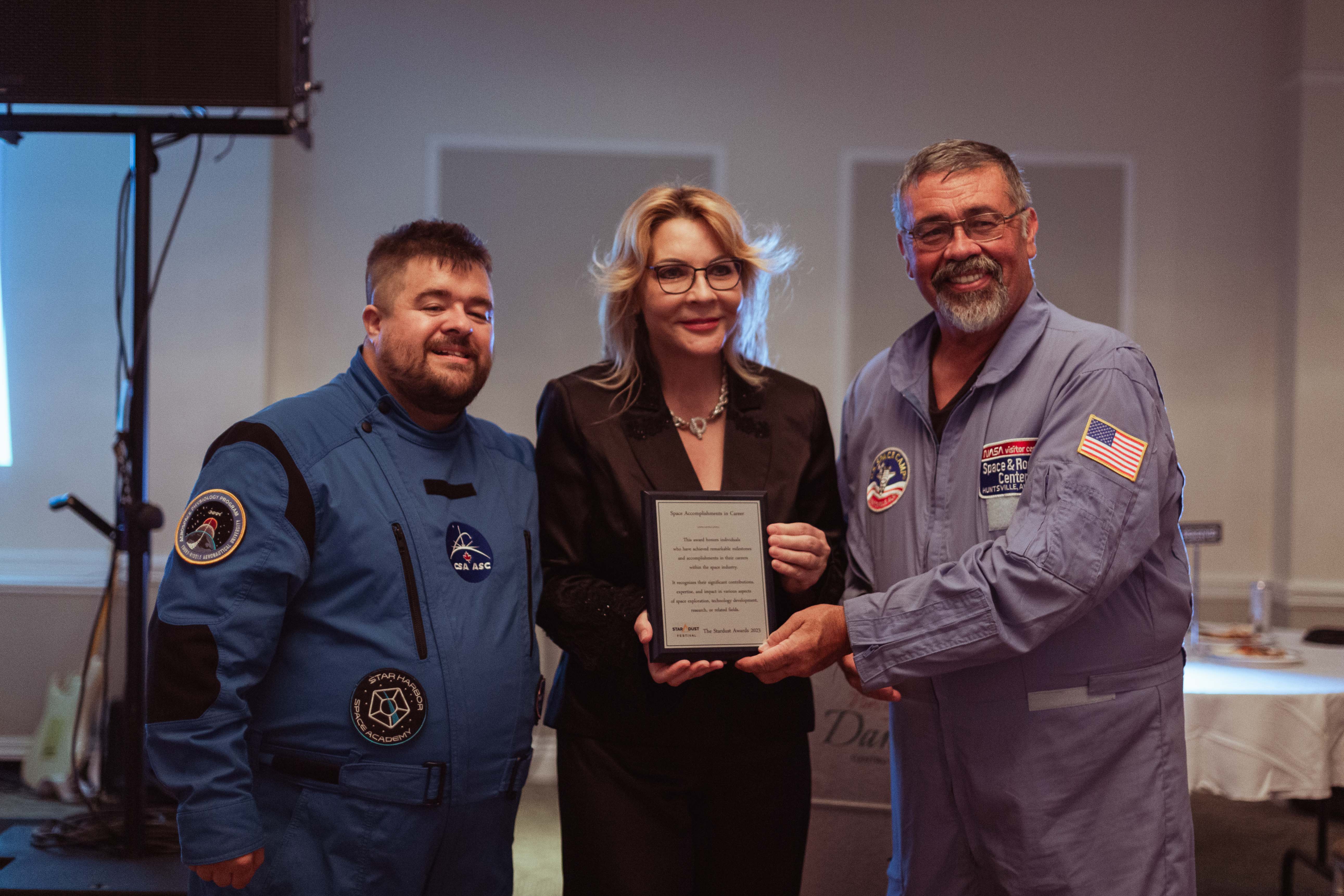 smiling representatives from the the CSA and NASA visitors centre in Huntsville with a Stardust Festival award plaque.