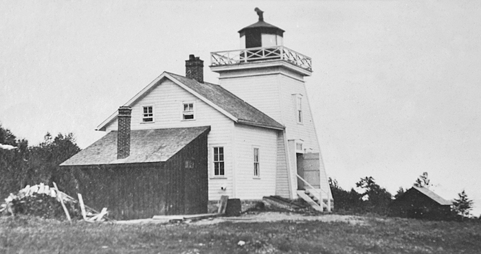 The Gore Bay Lighthouse; a short, square lighthouse with a a white cottage next to it for the lighthouse keeper. 