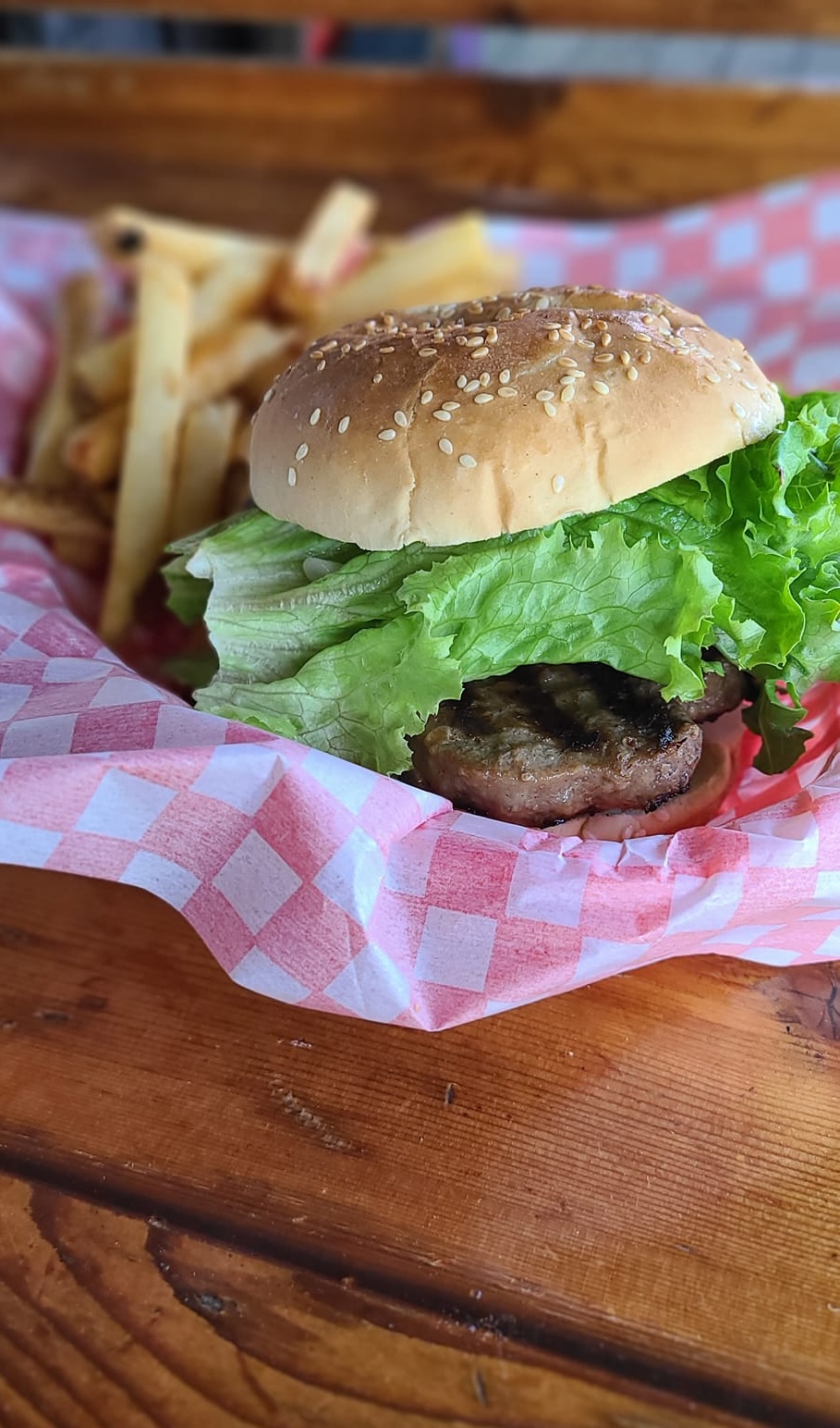 a burger and fries from the Hungry Bear Restaurant on a wooden picnic table. 