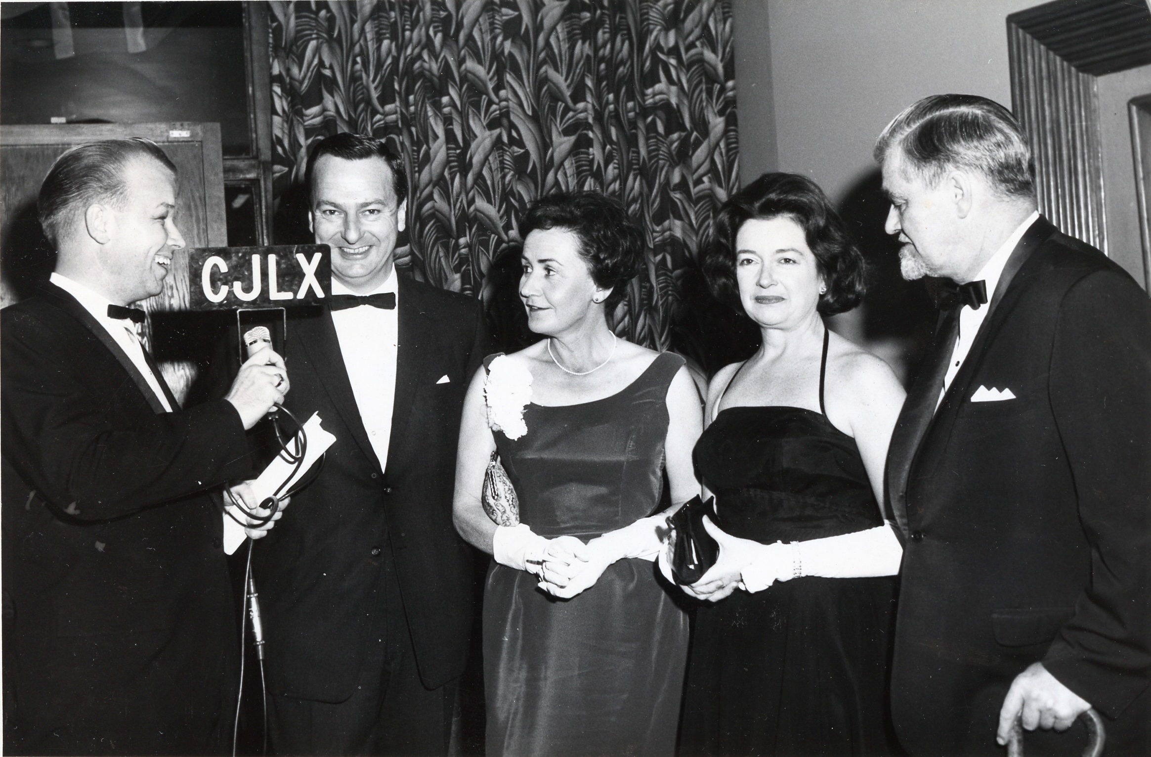 Interviewing Port Arthur’s famed children's author Sheila Burnford at the November 1963 premiere of the Disney film Incredible Journey. Sheila and 4 other smiling people, one with a microphone, all wearing formal wear.