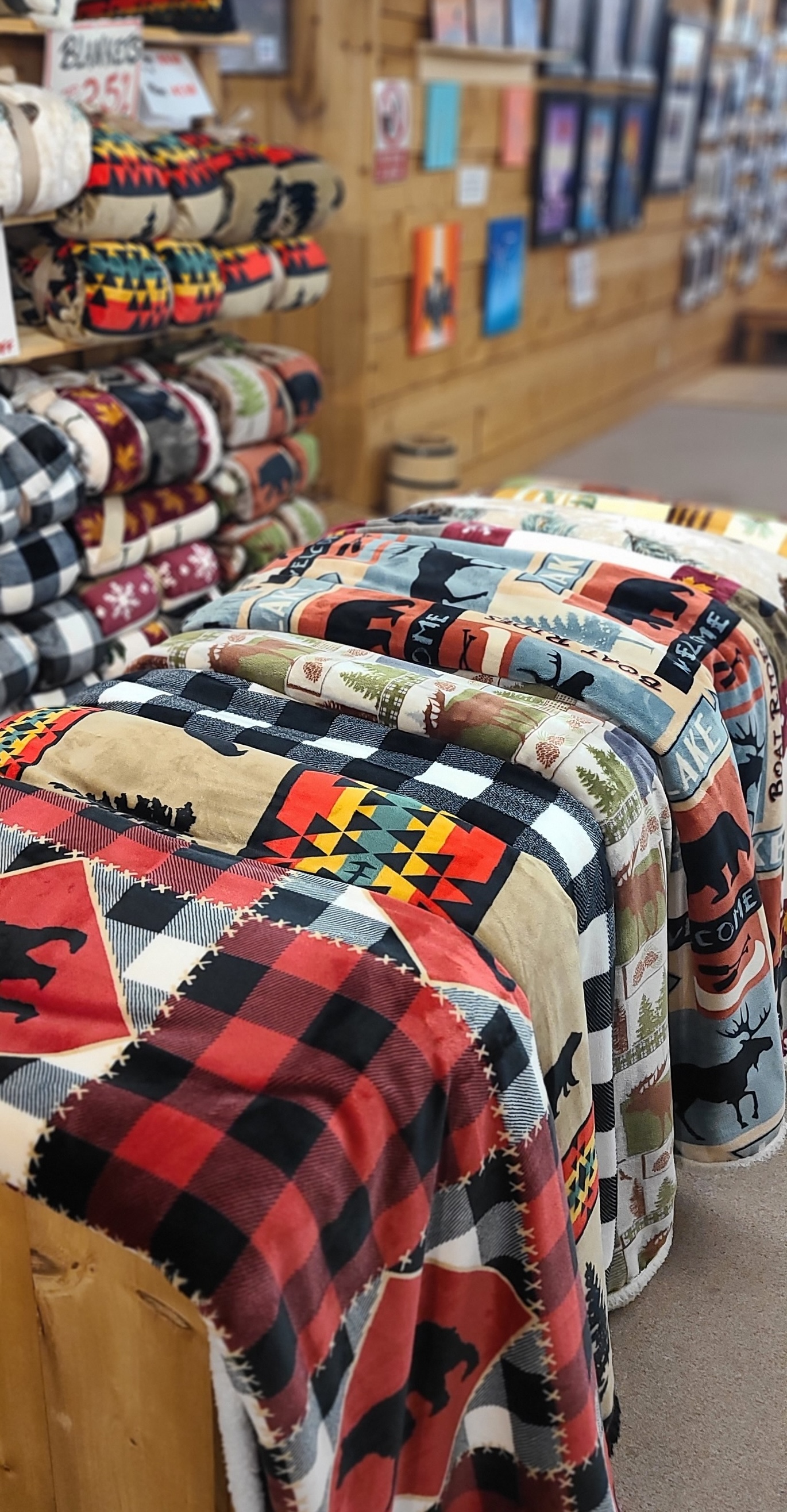 fleece blankets in a wide variety of patterns, folded neatly on display shelves in the French River Trading Post.