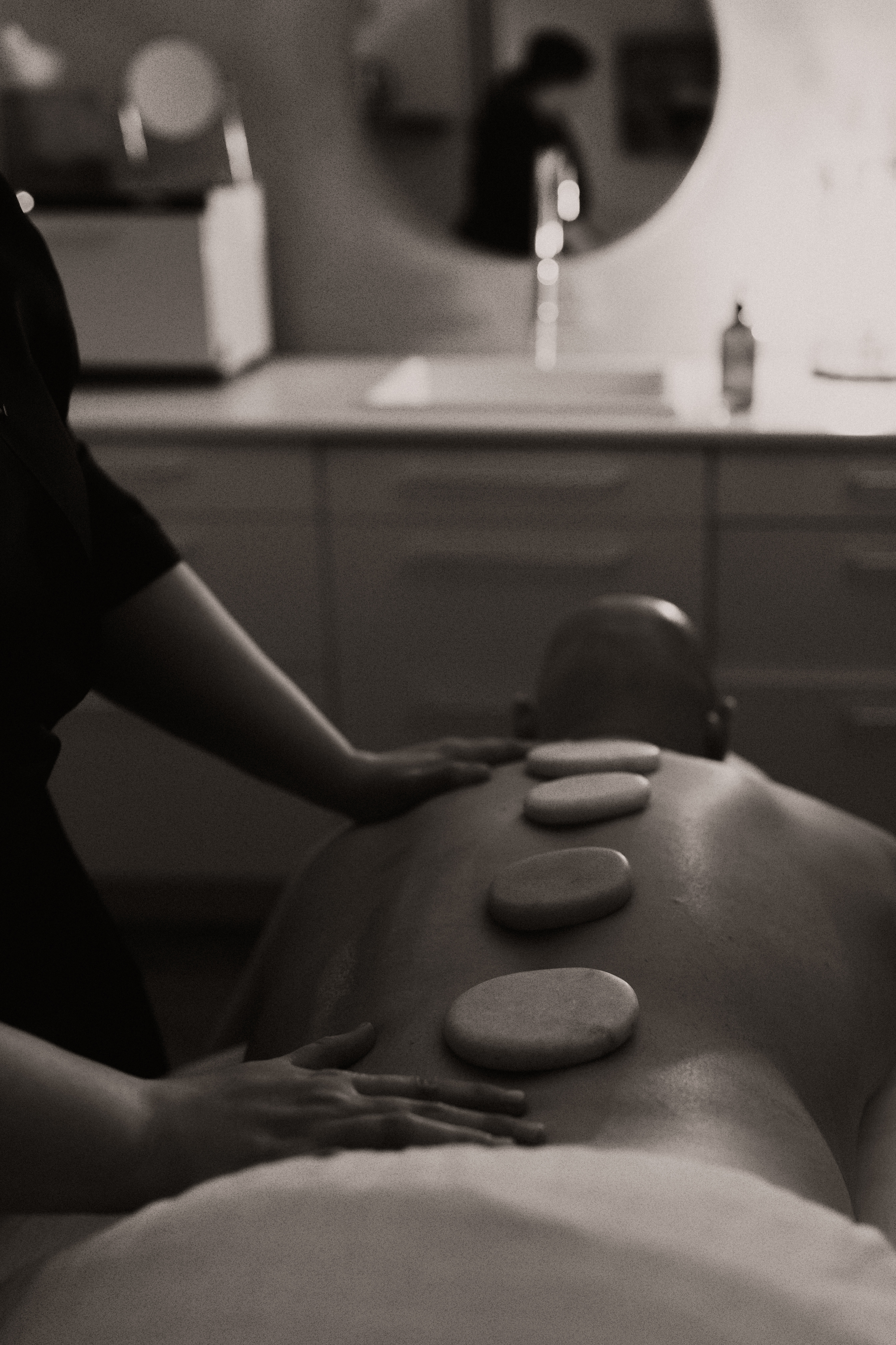 a black and white photo of a person laying on his stomach without a shirt and round disks on his back