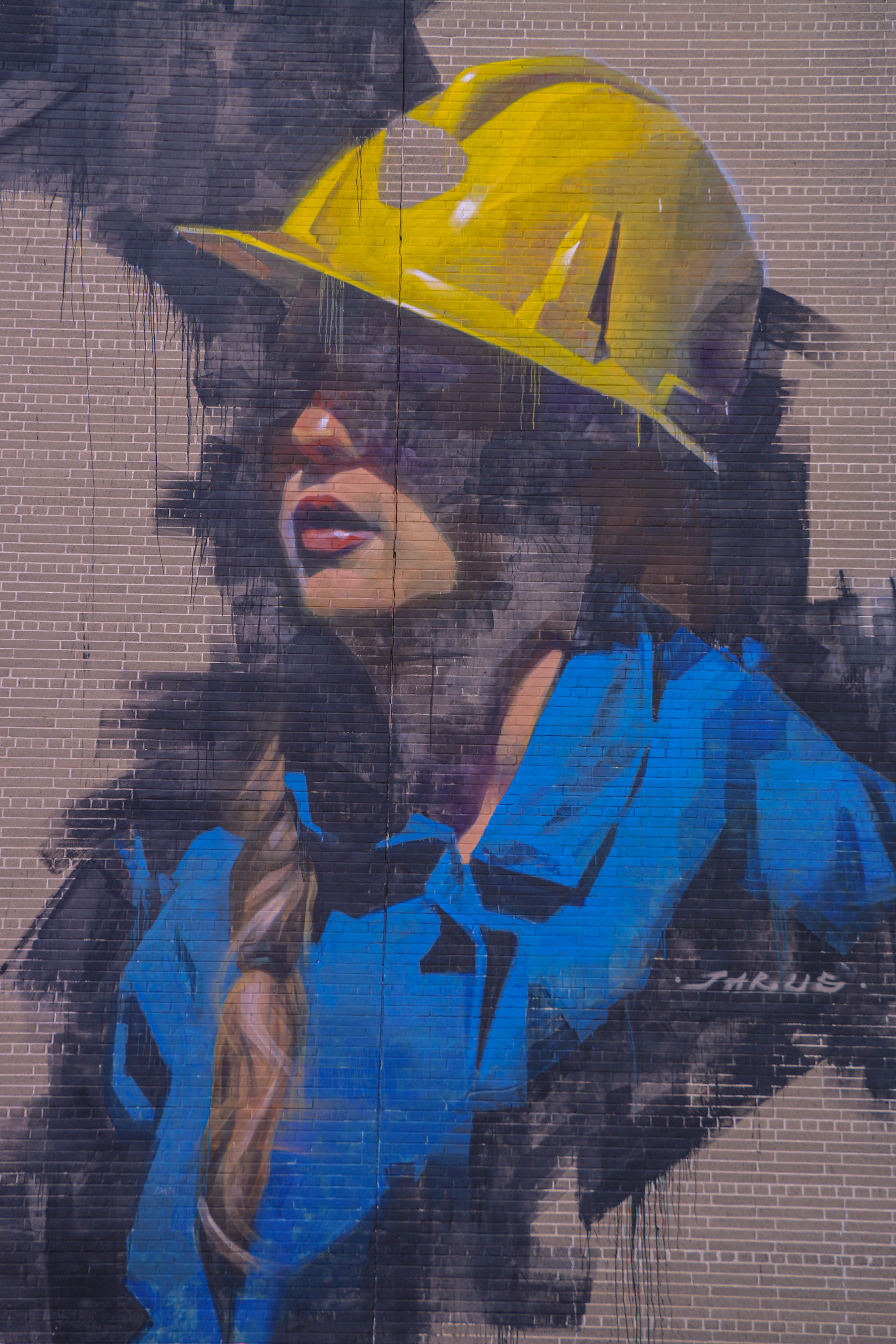 Mural of woman wearing a yellow hard hat