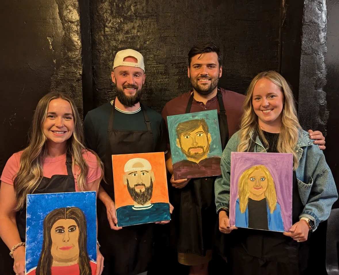 A group holding up their self portraits 