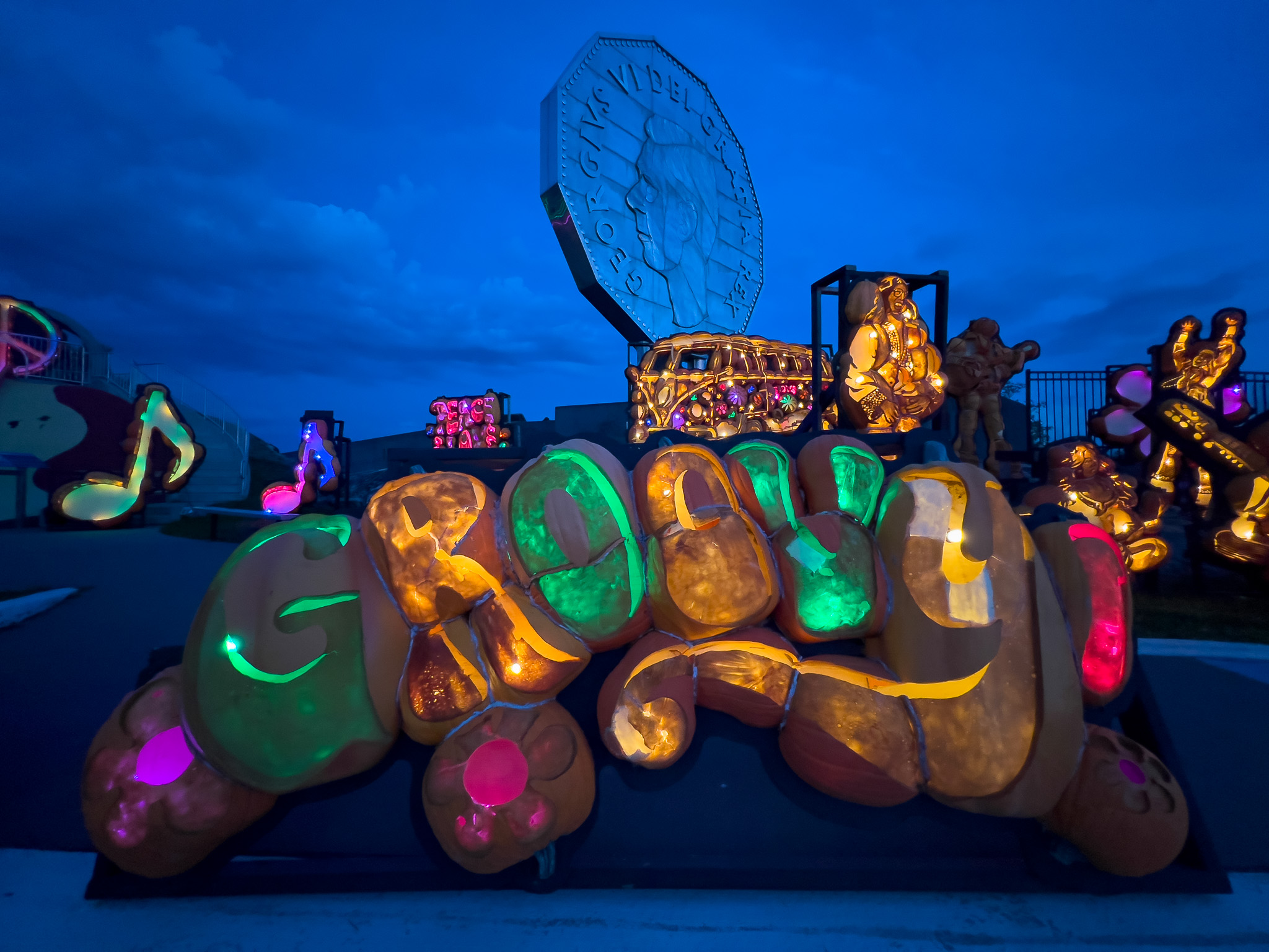 dozens of pumpkins carved and stacked together to create large, illuminated sculptures in front of the Big Nickel in Sudbury.