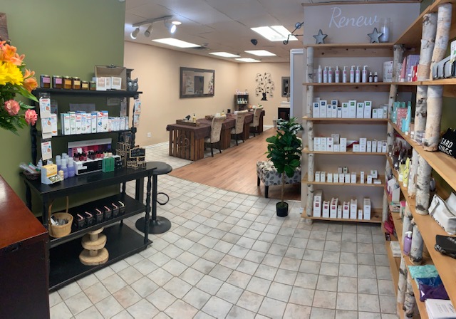 A zoom-out of the store entrance which has beauty products stacked on shelves on either side of the photo and manicure stations in the far back center