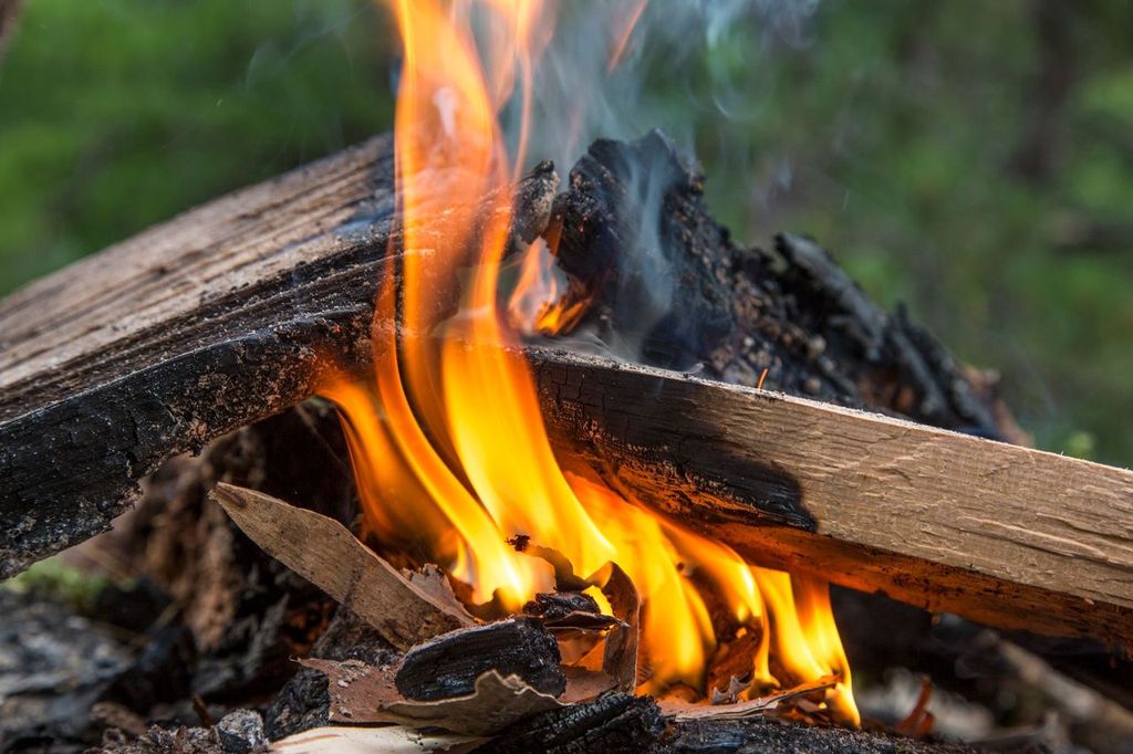 tinder lit under larger logs, the flame travelling upward to catch the larger wood.