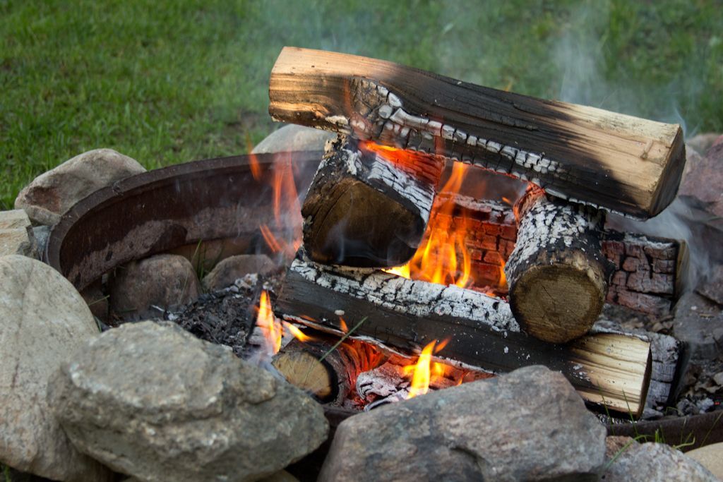 a glowing campfire with the wood stacked into a box or "log cabin" structure around the flame.