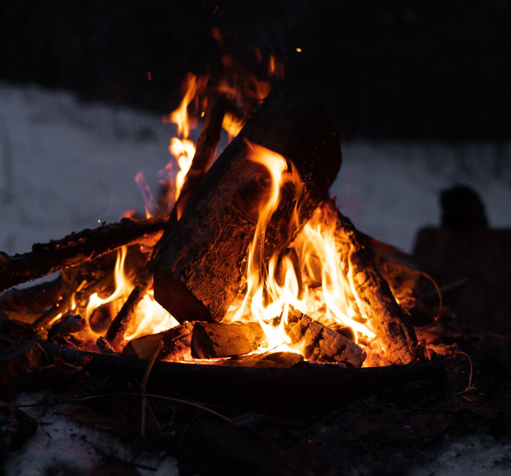 a campfire with the wood leaning together in a triangular or "teepee" formation around the flame.