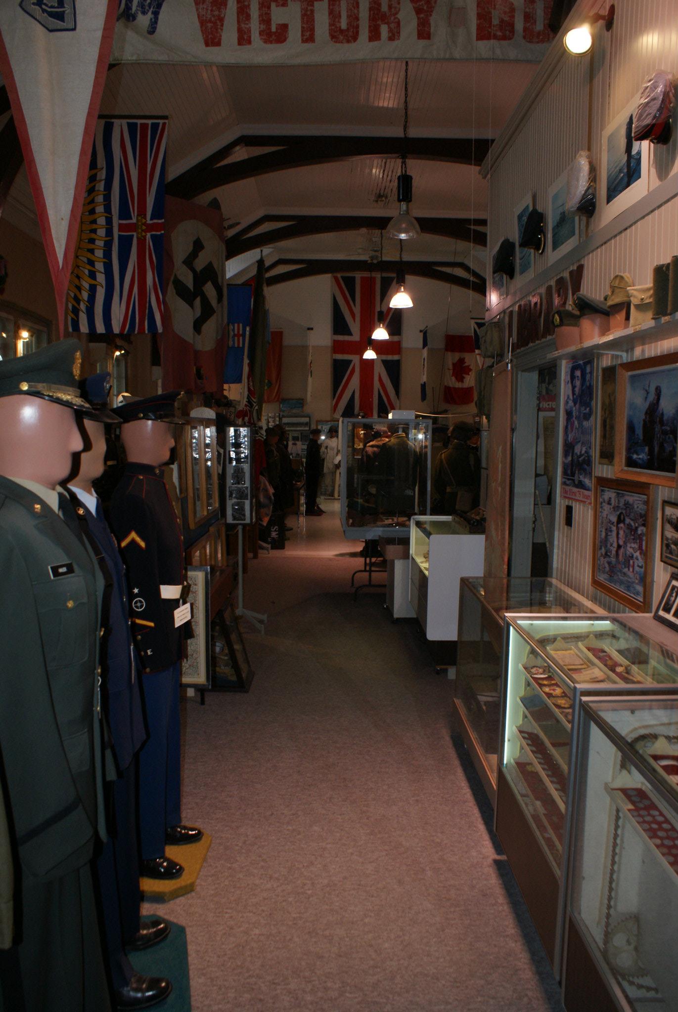 Inside the gallery at the Bunker Military Museum; a long, dark corridor lined with war artifacts and mannequins wearing uniforms from the last century's wars.