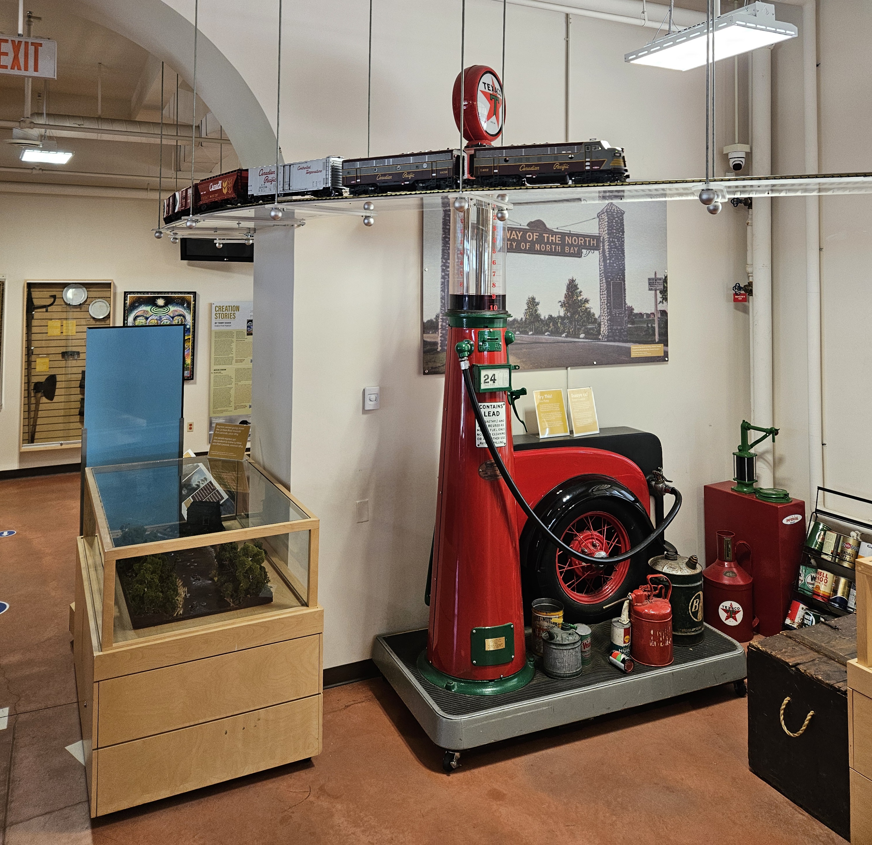 Displays at the North Bay Museum, with a remote control model train chugging along a miniature track suspended from the ceiling. 