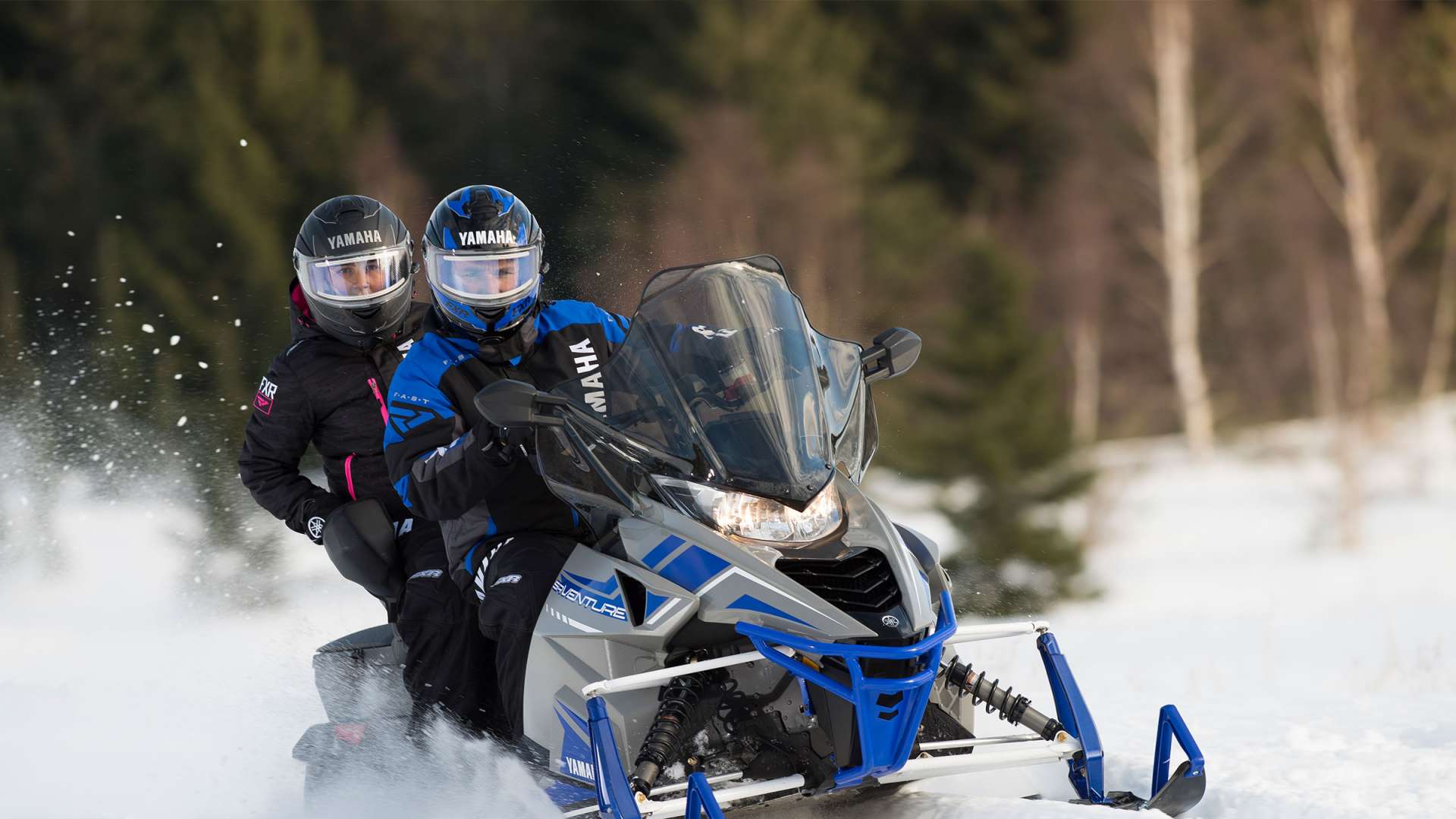 Two people on a snowmobile.