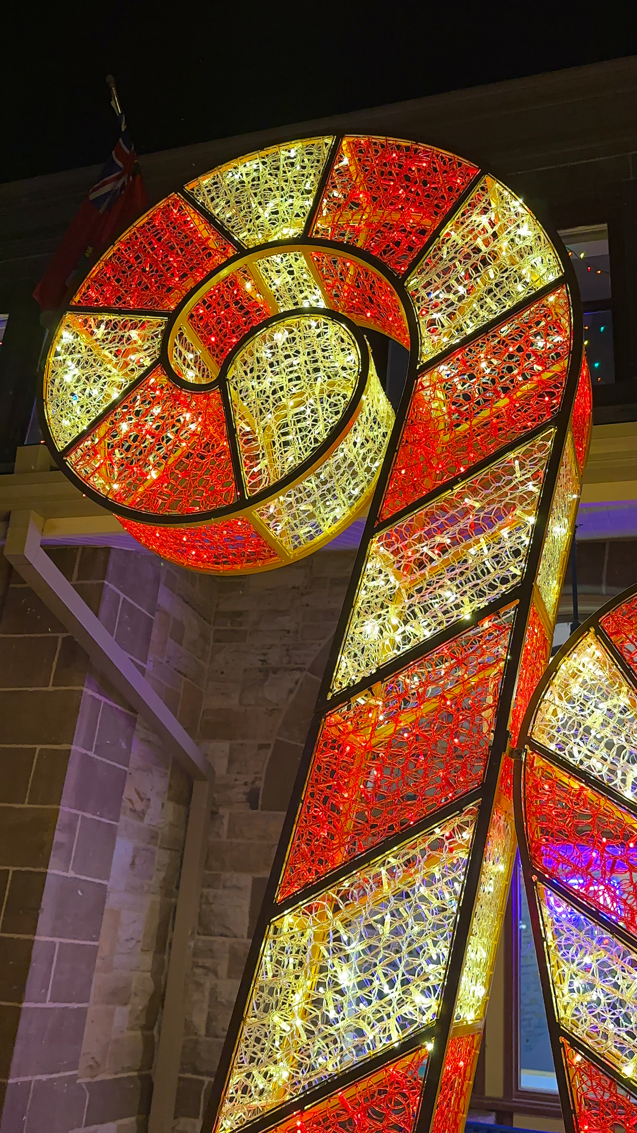 A giant light up candy cane at night.