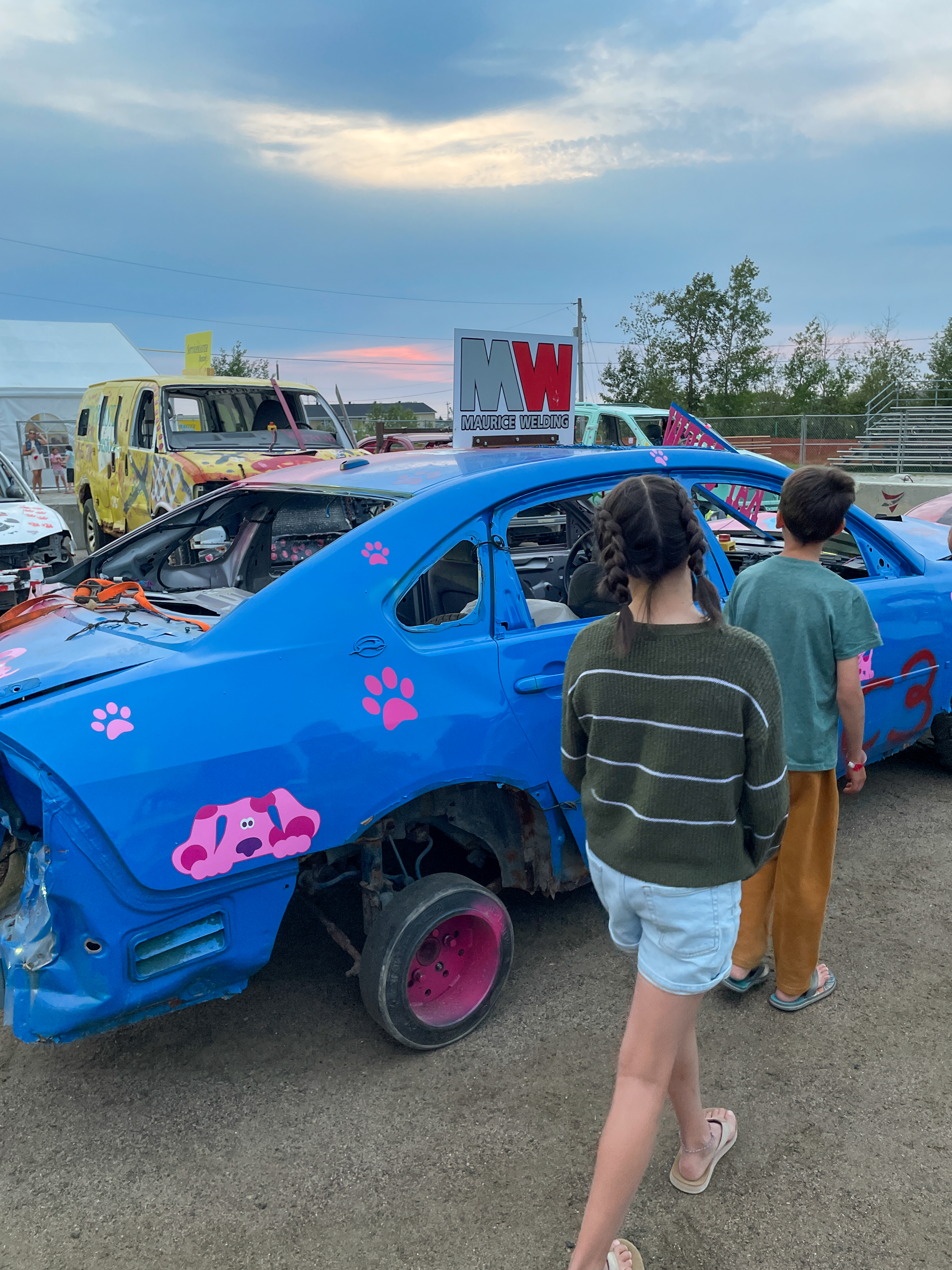 Two children passing a derby car